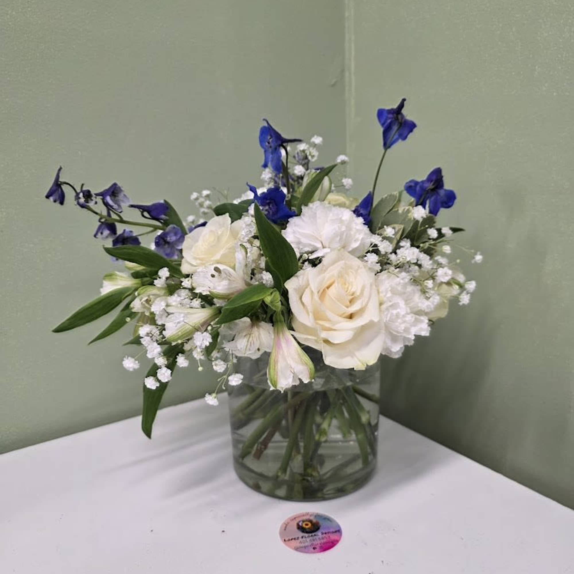 Soft white blooms and graceful blue delphiniums come together in a clear Soft white blooms and graceful blue delphiniums come together in a clear