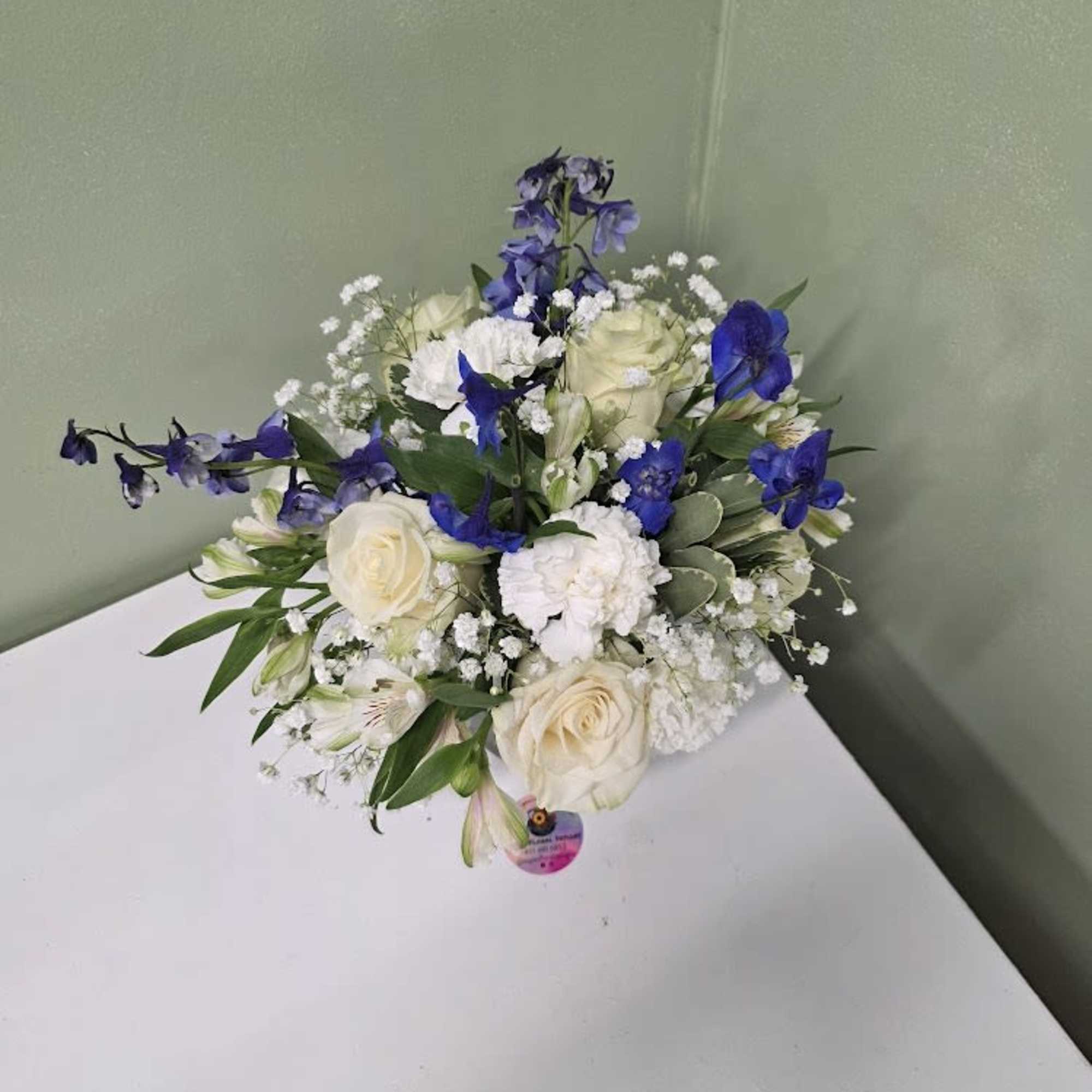 Soft white blooms and graceful blue delphiniums come together in a clear Soft white blooms and graceful blue delphiniums come together in a clear