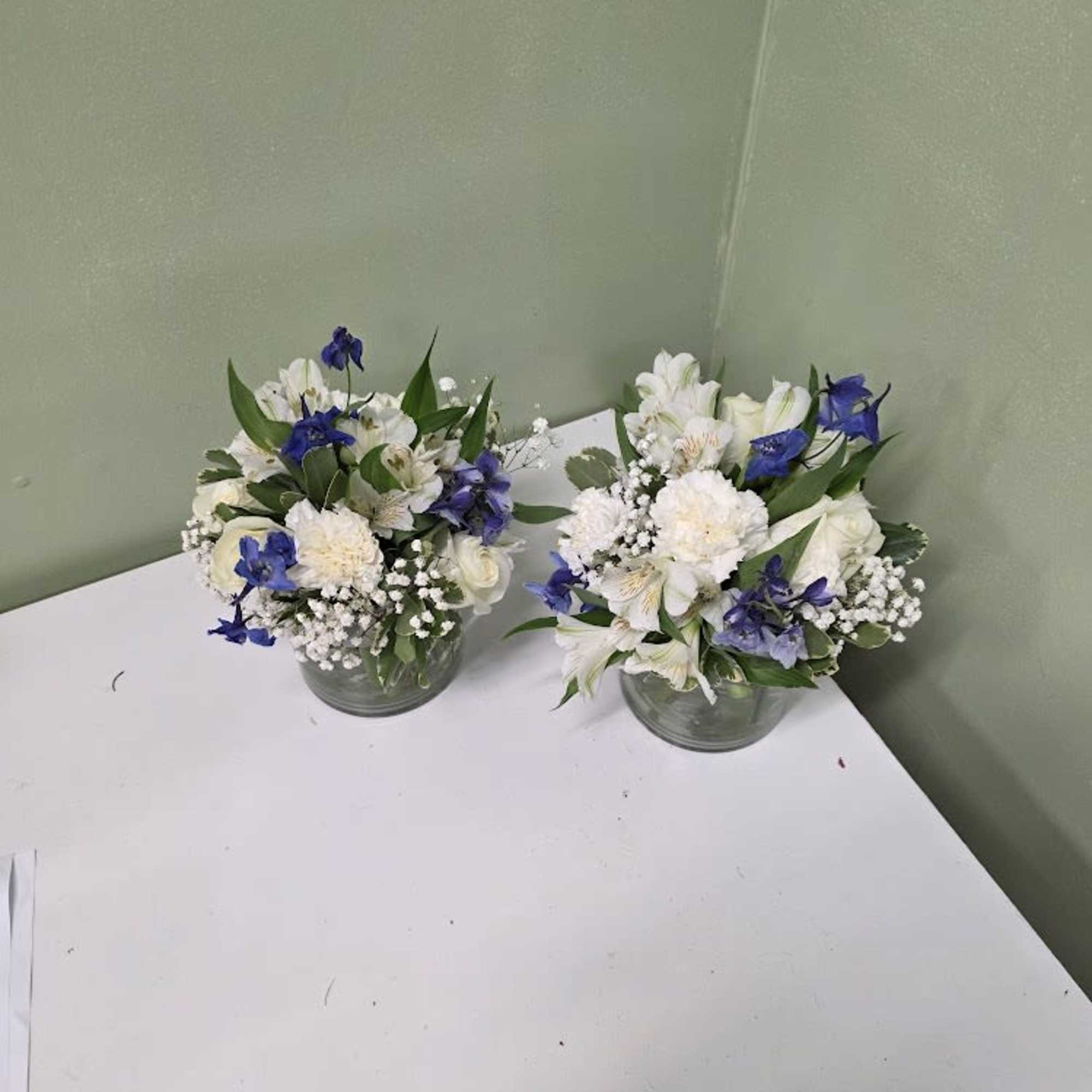 Soft white blooms and graceful blue delphiniums come together in a clear Soft white blooms and graceful blue delphiniums come together in a clear