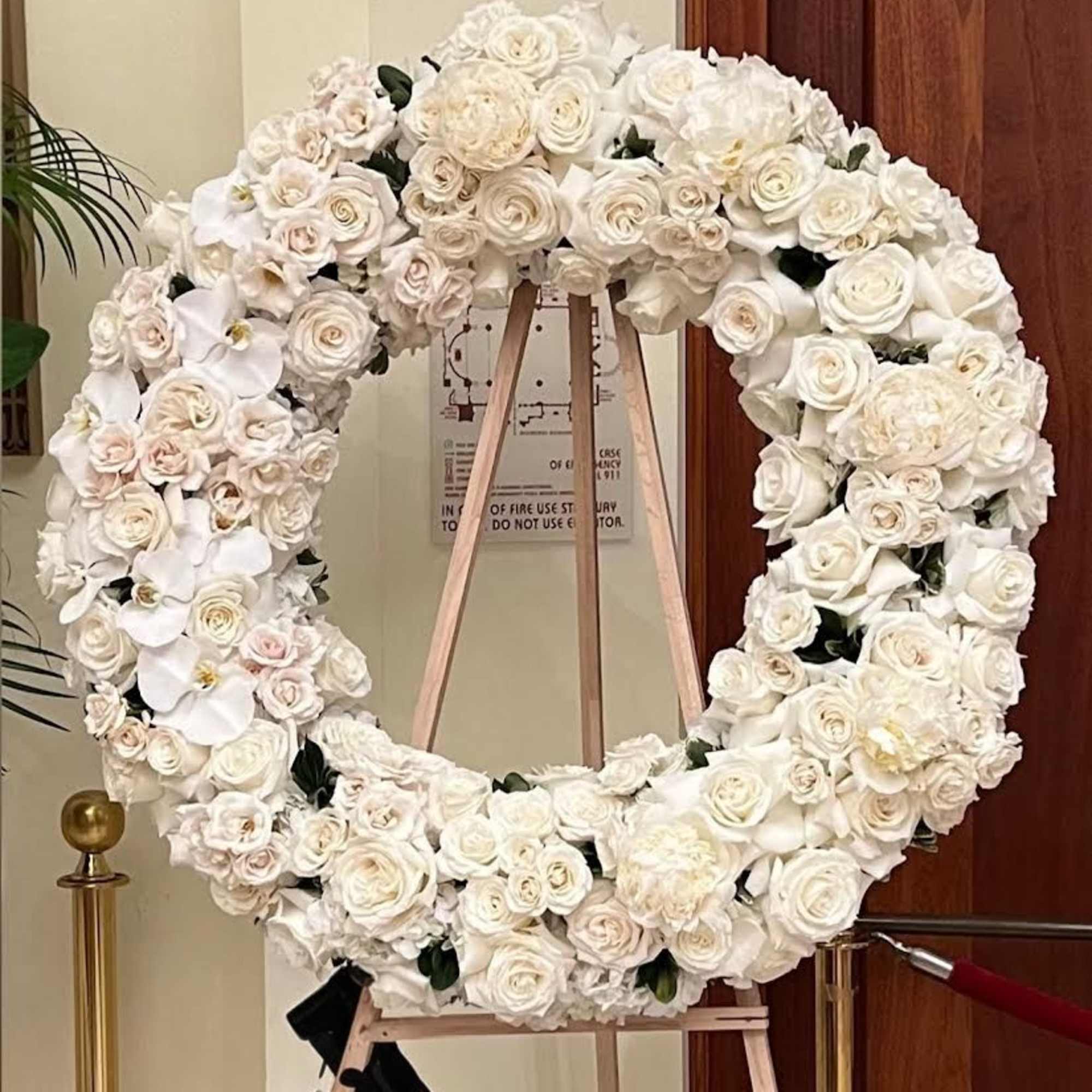 This sophisticated and graceful wreath features a harmonious blend of white roses This sophisticated and graceful wreath features a harmonious blend of white roses