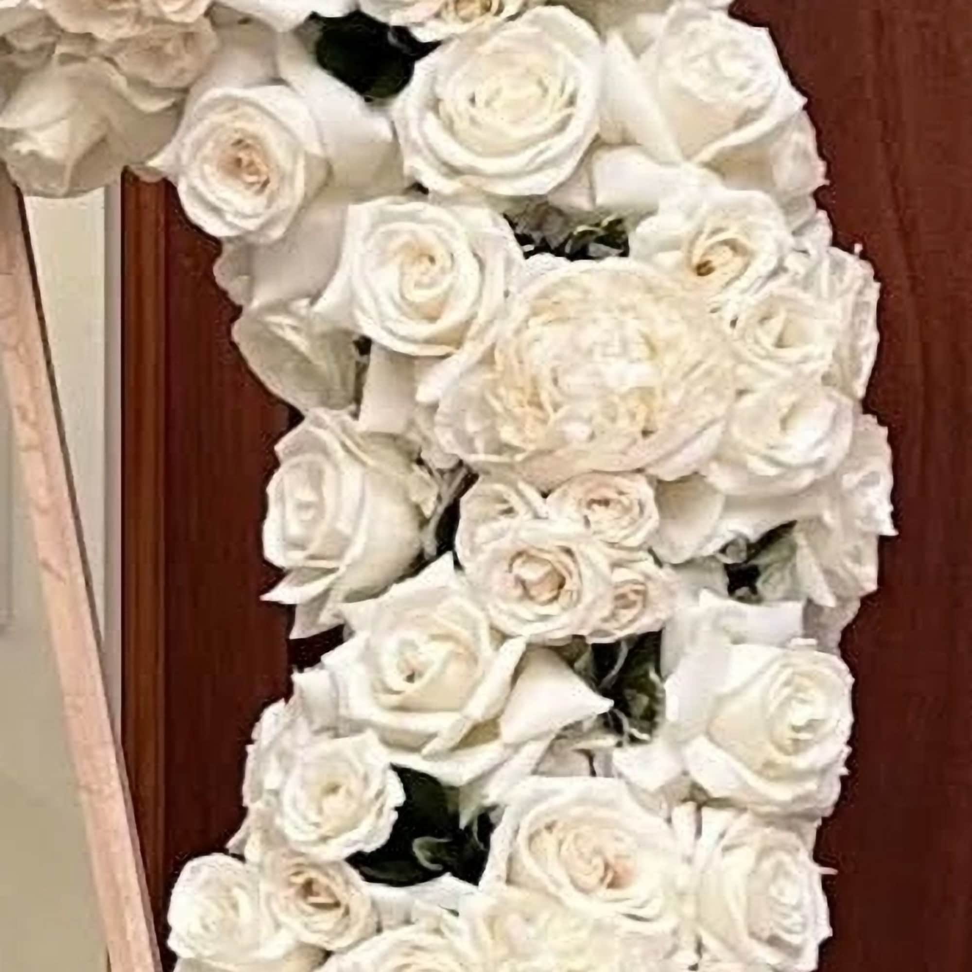 This sophisticated and graceful wreath features a harmonious blend of white roses This sophisticated and graceful wreath features a harmonious blend of white roses