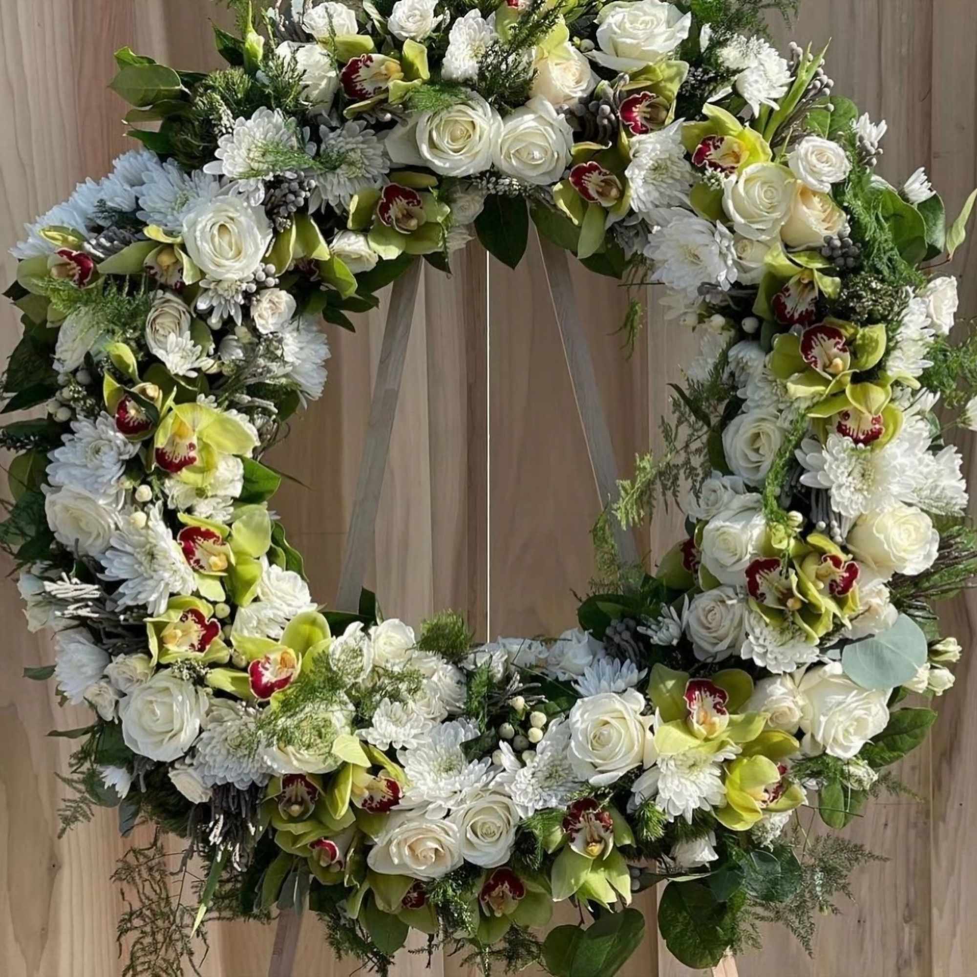 This elegant wreath is a harmonious blend of white roses, chrysanthemums, and This elegant wreath is a harmonious blend of white roses, chrysanthemums, and