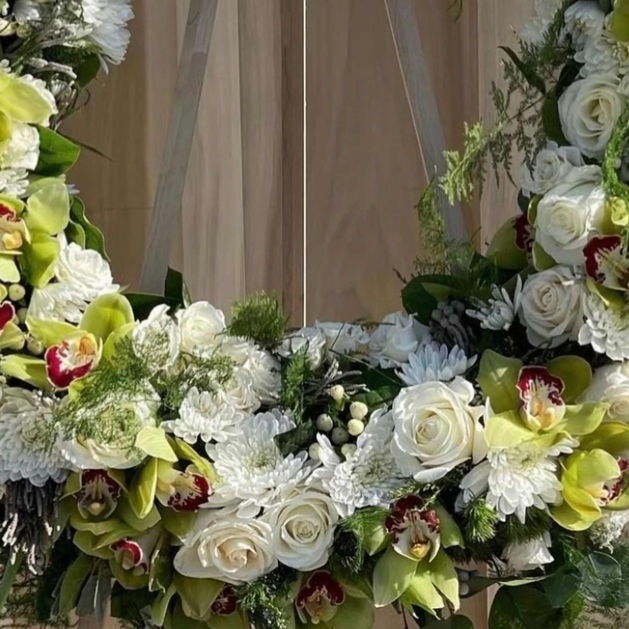This elegant wreath is a harmonious blend of white roses, chrysanthemums, and This elegant wreath is a harmonious blend of white roses, chrysanthemums, and