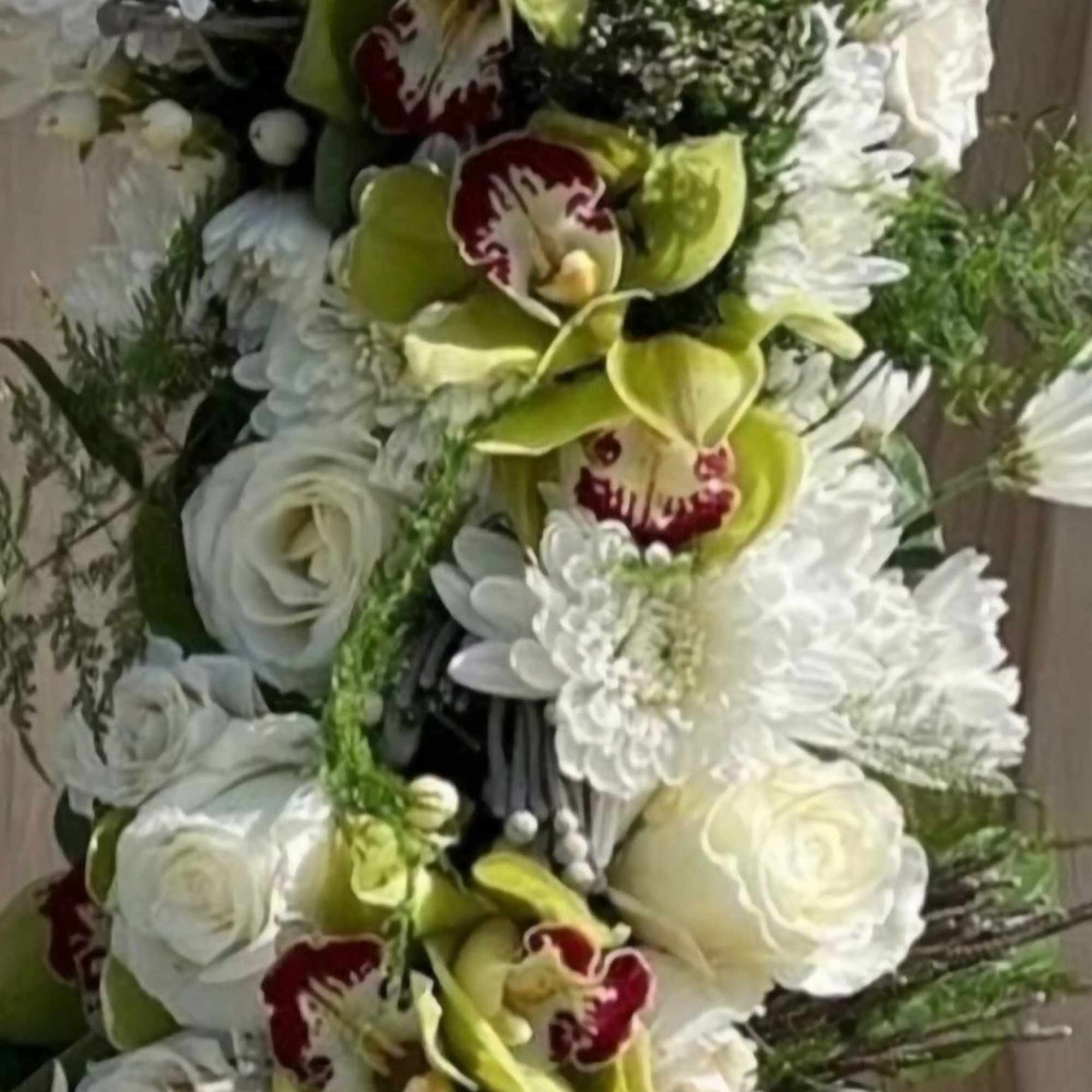 This elegant wreath is a harmonious blend of white roses, chrysanthemums, and This elegant wreath is a harmonious blend of white roses, chrysanthemums, and