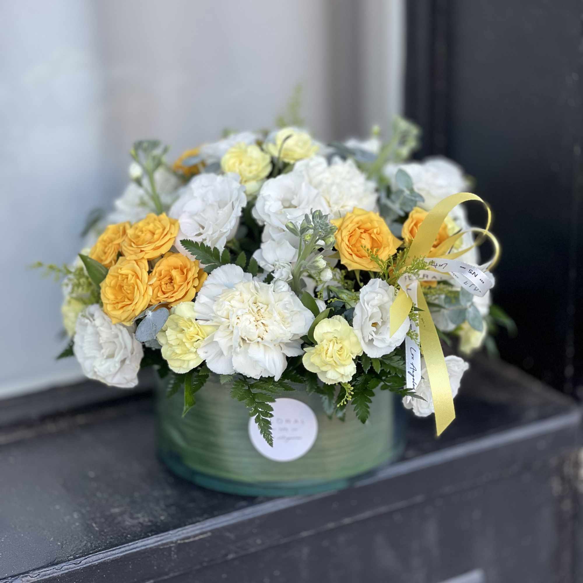 A modern take on floral gifting, this mixed white and yellow arrangement