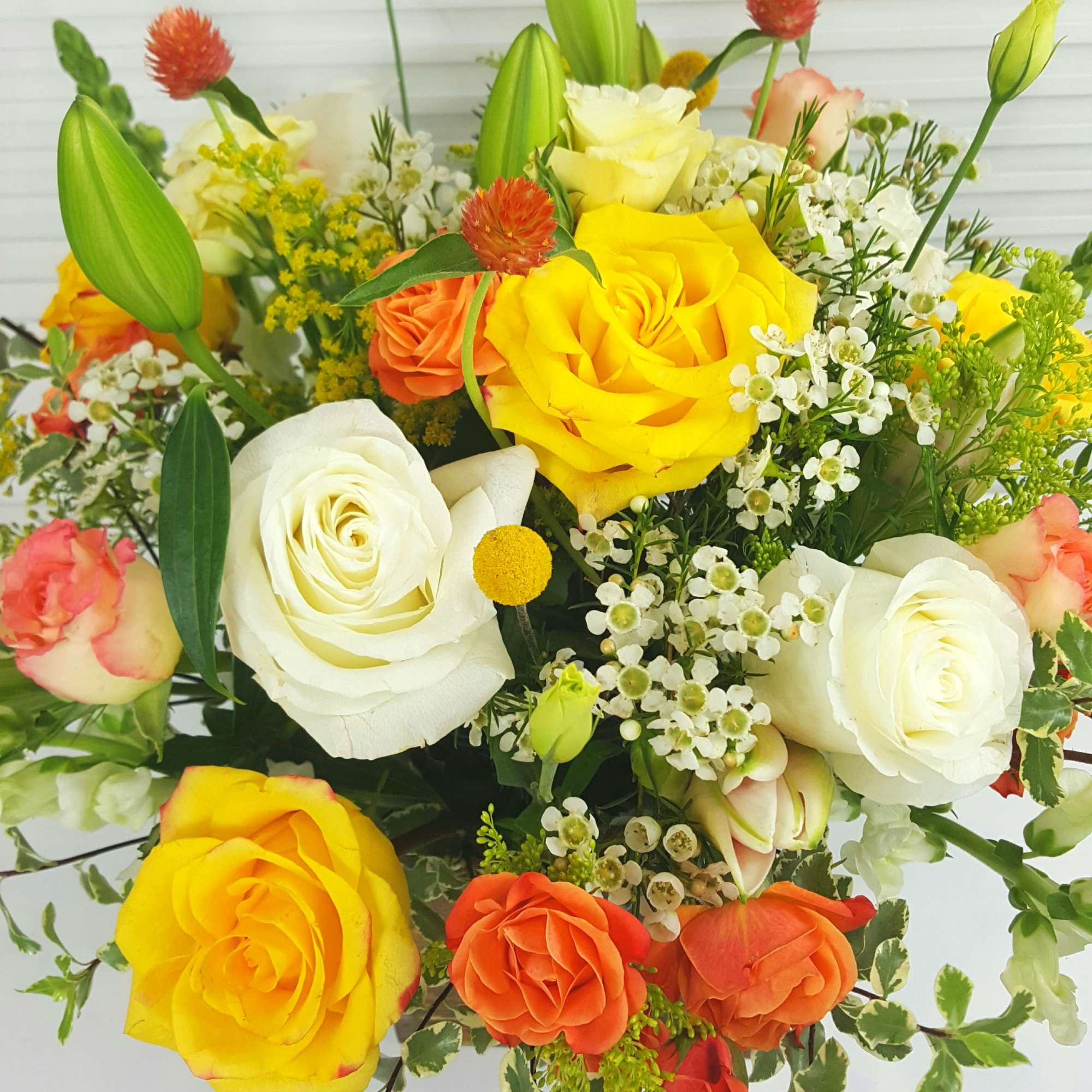 White and Yellow rosrs, snap, lilies, peach african roses, solidago, waxflower, and