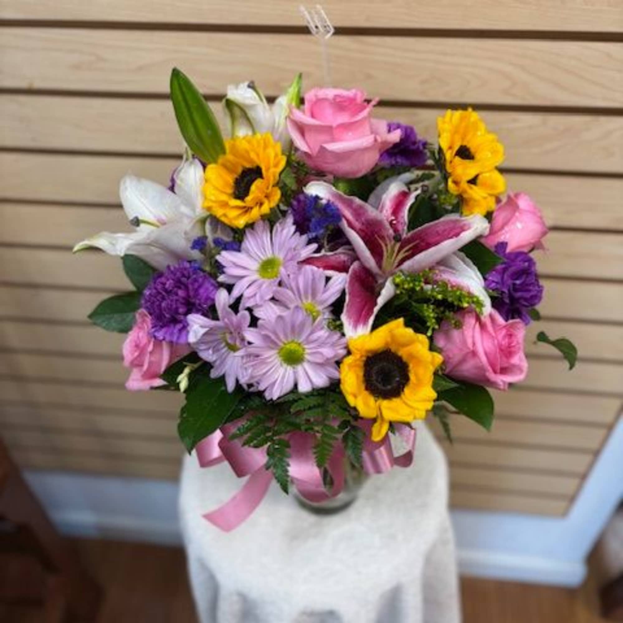 Mixed cut arrangement with stargazer lilies, white oriental lily, pink roses, sunflowers