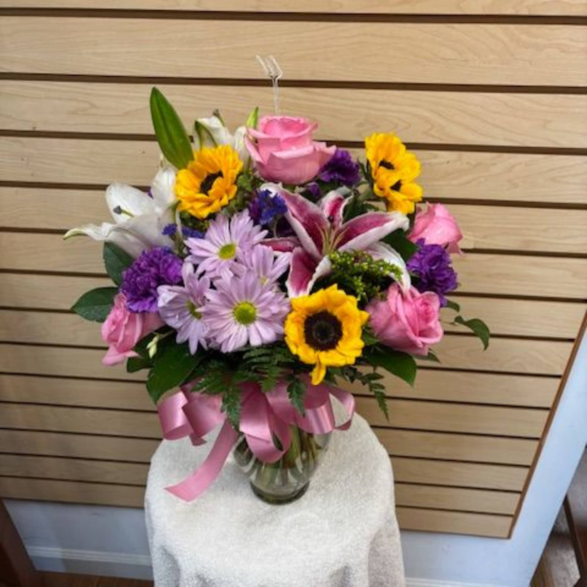 Mixed cut arrangement with stargazer lilies, white oriental lily, pink roses, sunflowers