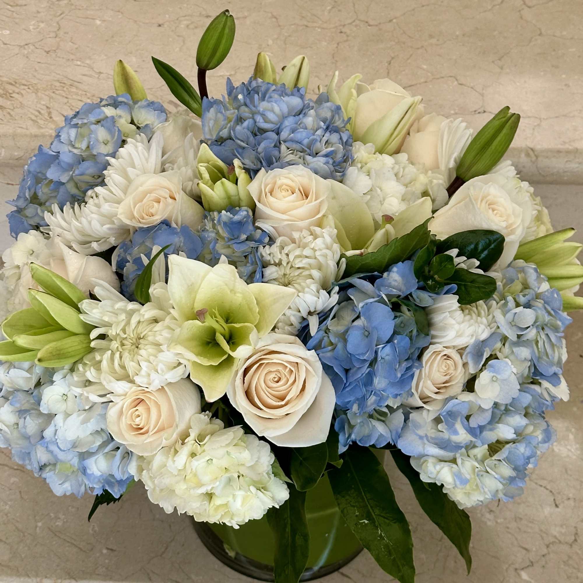 Blue and White mix of Flowers with Hydrangeas, Roses, Lilies and more.