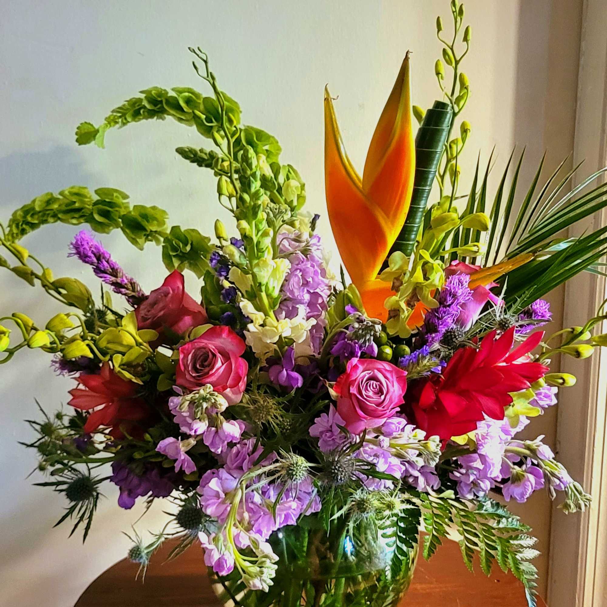 A beautiful design, in a glass sphere where tropical and in-season blooms