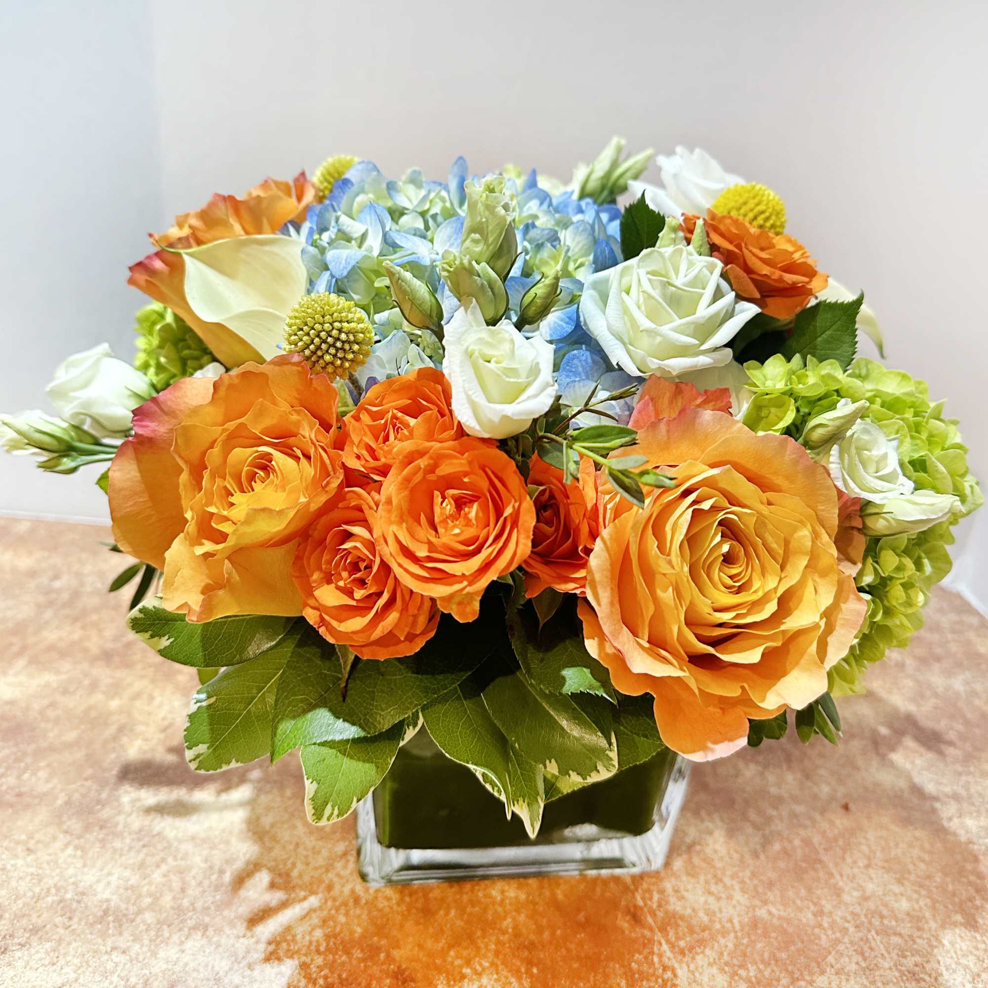 A bright color arrangement. This arrangement features bright blue and orange color A bright color arrangement. This arrangement features bright blue and orange color