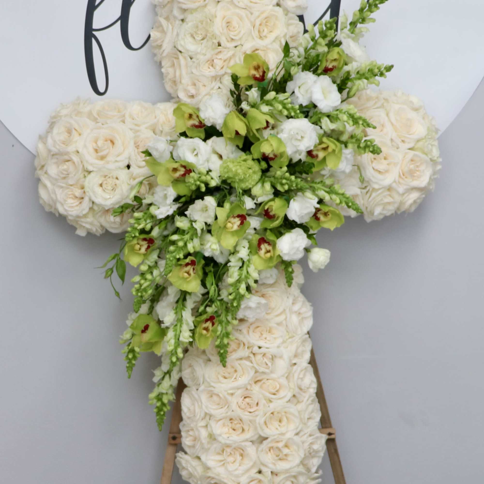 This cross is made with white roses and includes a design of