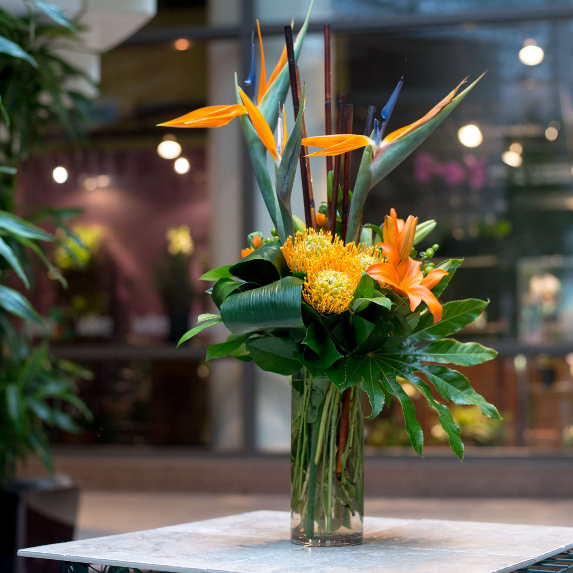Birds of Paradise with Pincushion Protea artistically designed with accompanying floral, foliage Birds of Paradise with Pincushion Protea artistically designed with accompanying floral, foliage