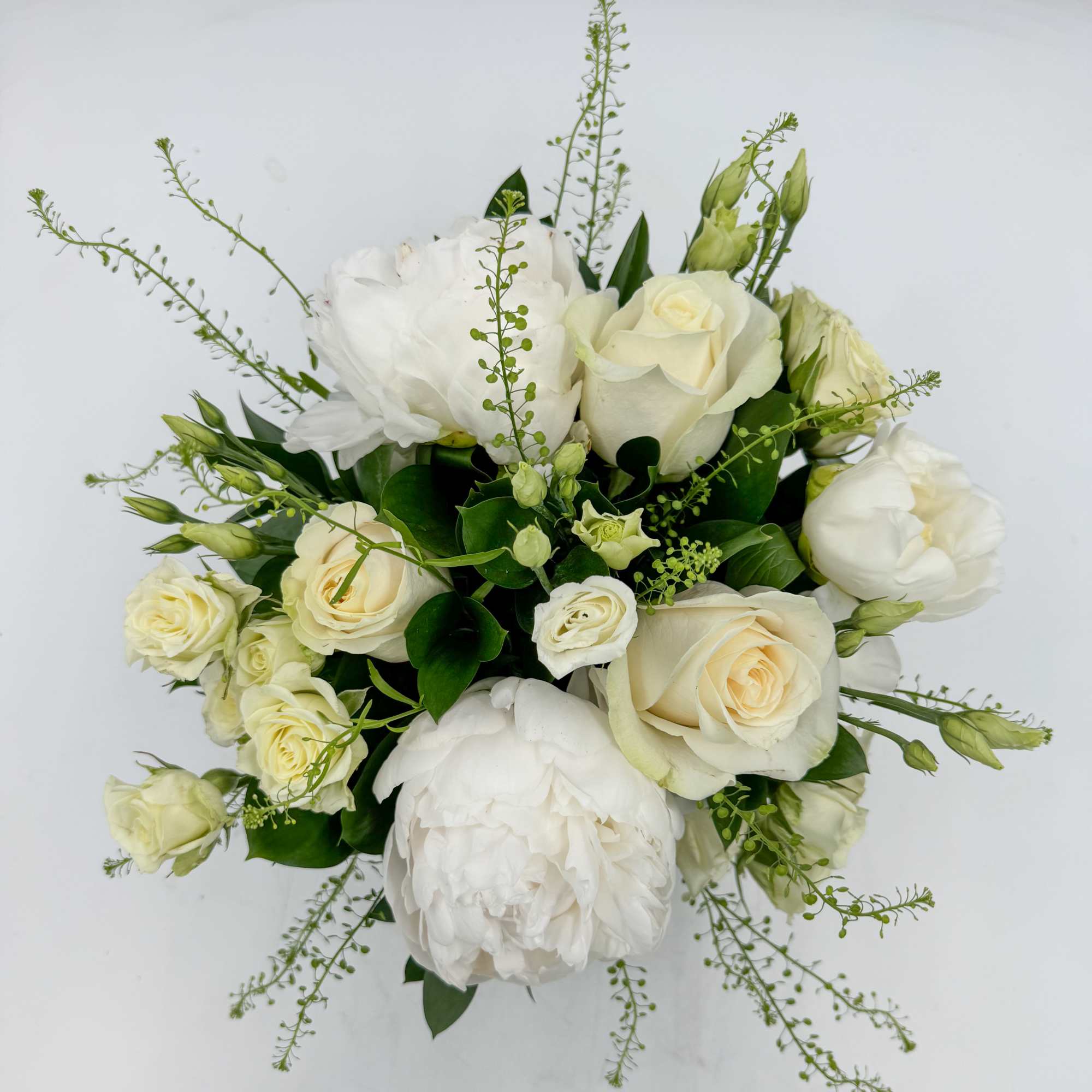 Beignet features White Peonies, Cream colored Vendela Roses, White Spray Roses and