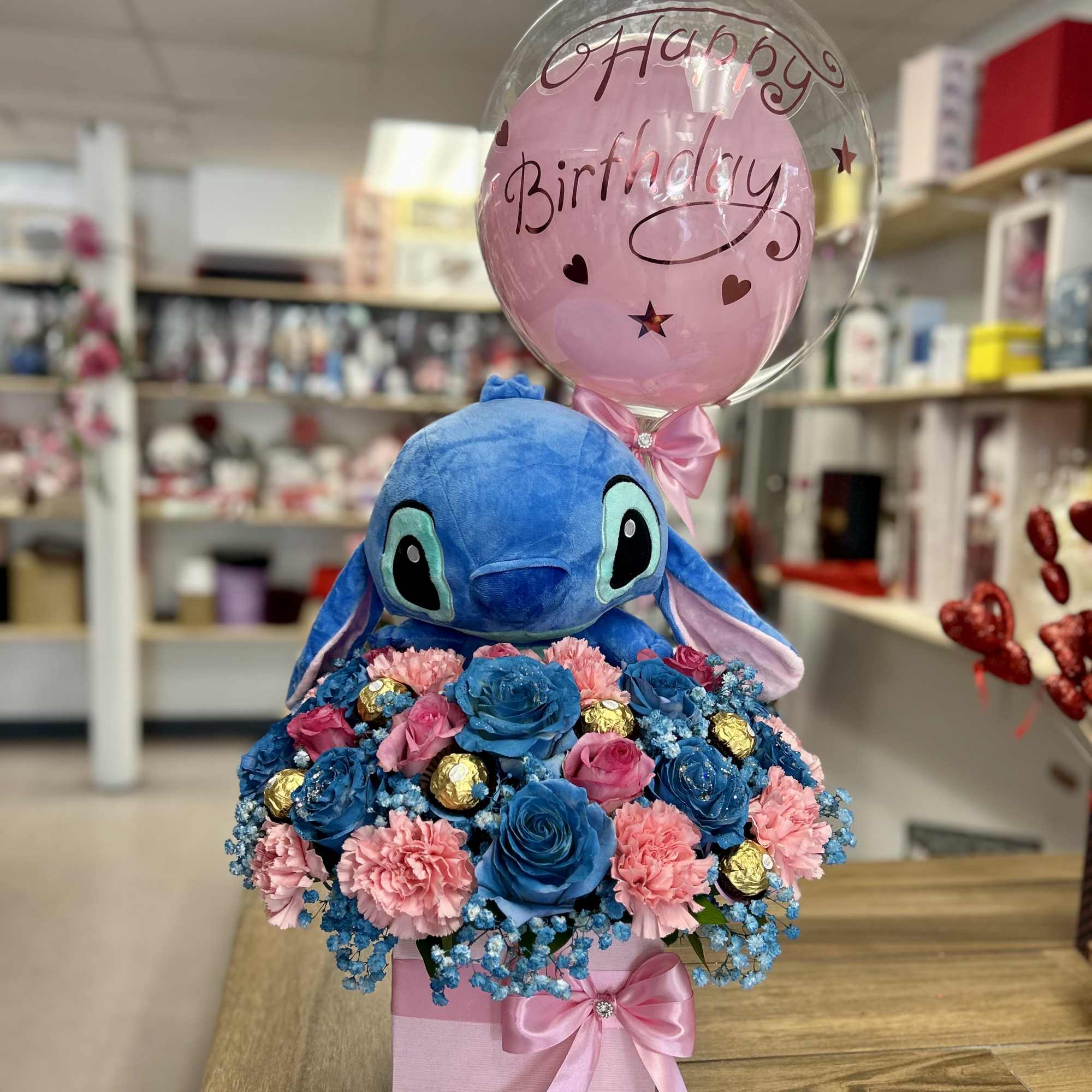 Beautiful arrangement with seasonal flowers, with stitch plush, balloon and chocolates!.
Hermoso arreglo