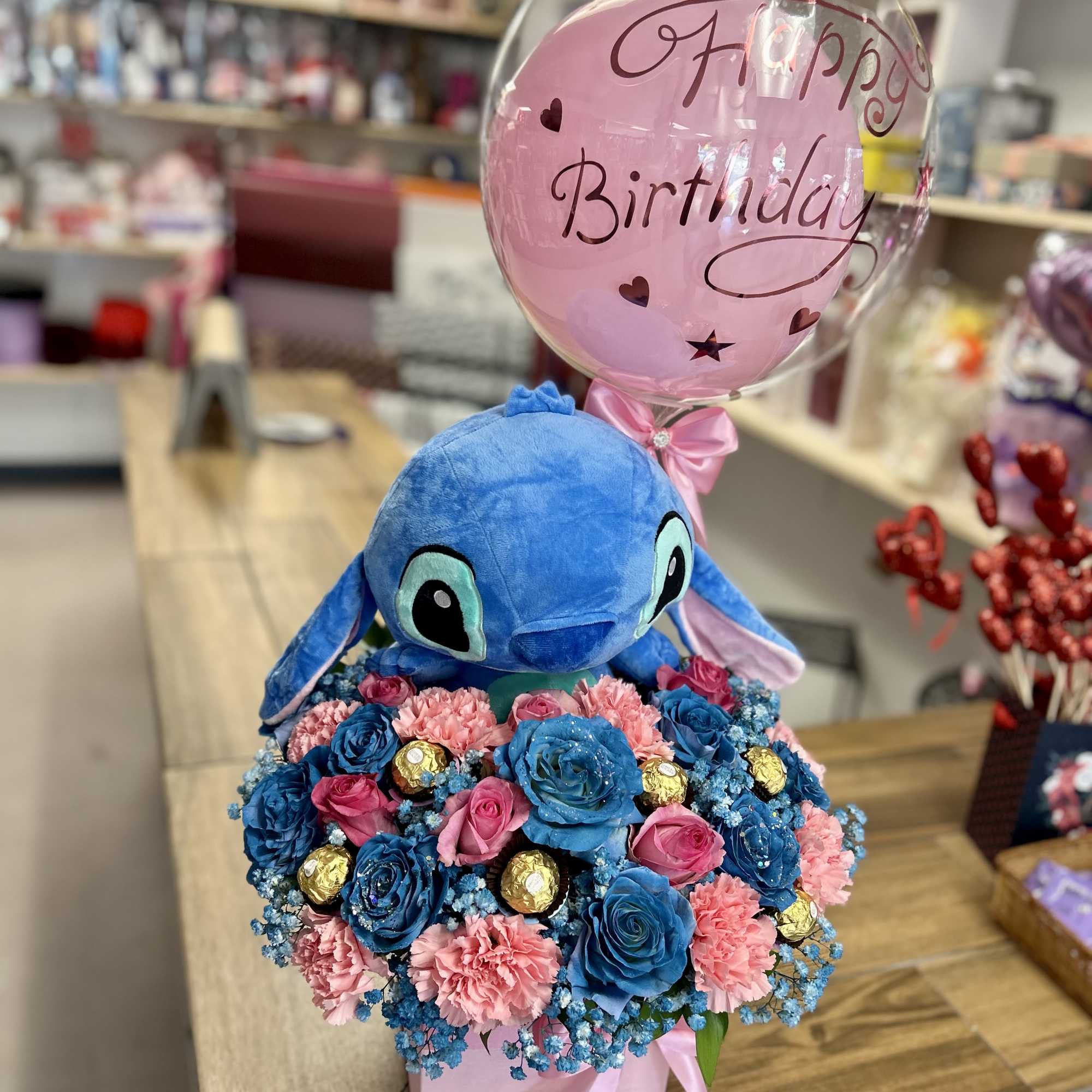 Beautiful arrangement with seasonal flowers, with stitch plush, balloon and chocolates!.
Hermoso arreglo