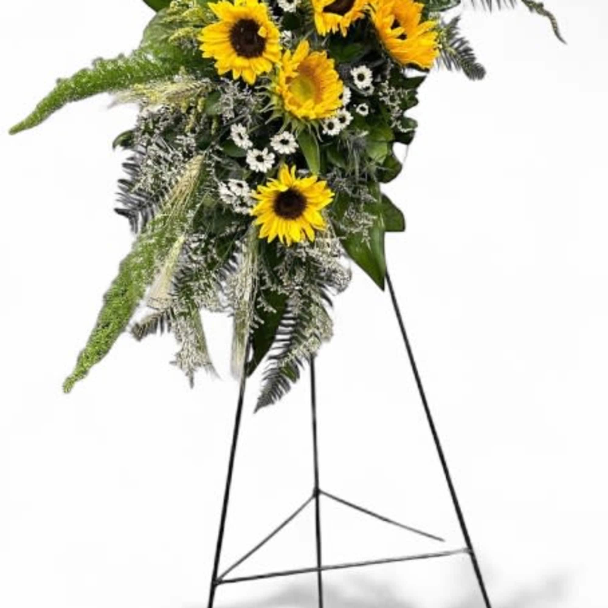 This casket spray, featuring sunflowers, daisies, and natural grasses, brings to mind This casket spray, featuring sunflowers, daisies, and natural grasses, brings to mind