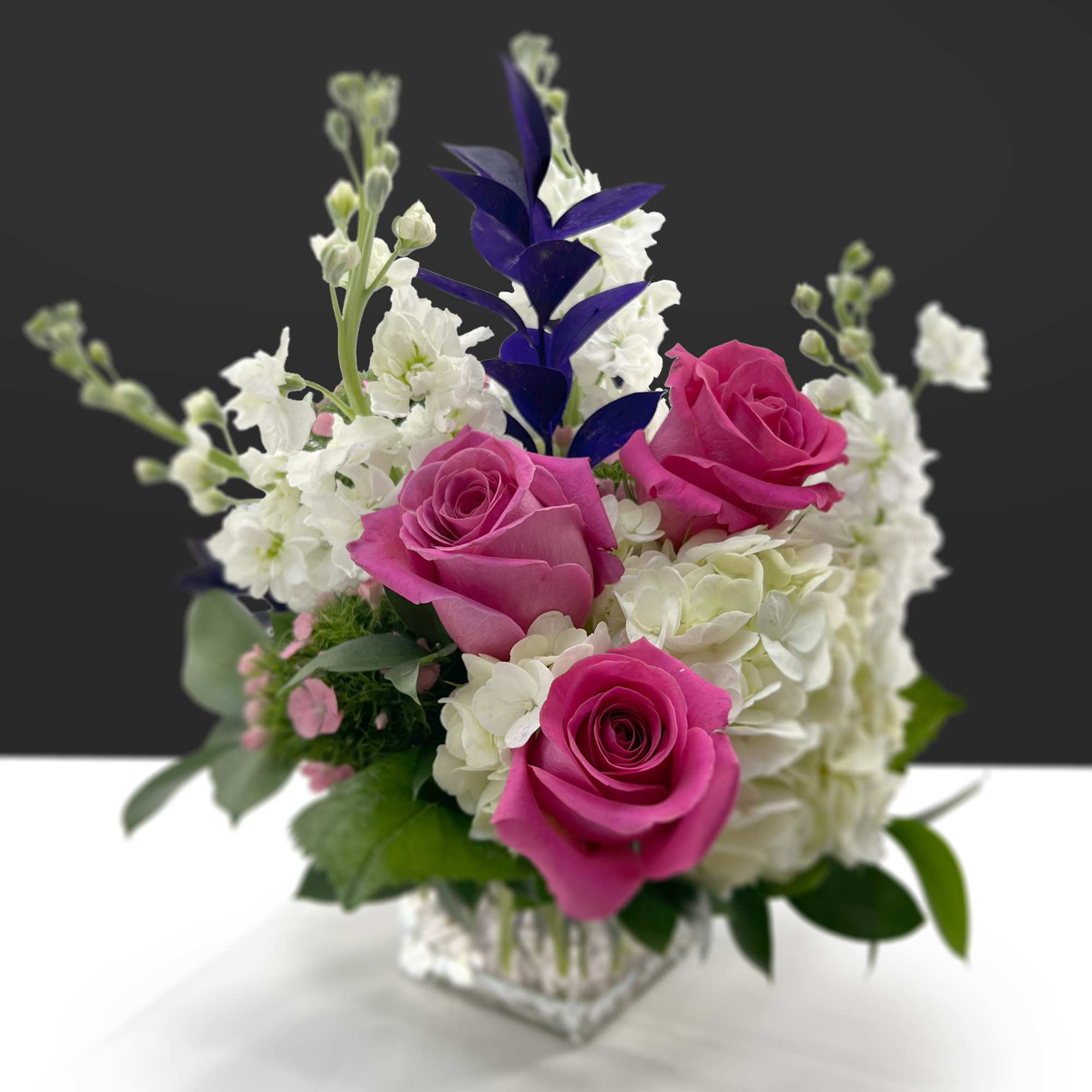 Highlights two shades of pink with roses and dianthus, accented by deep