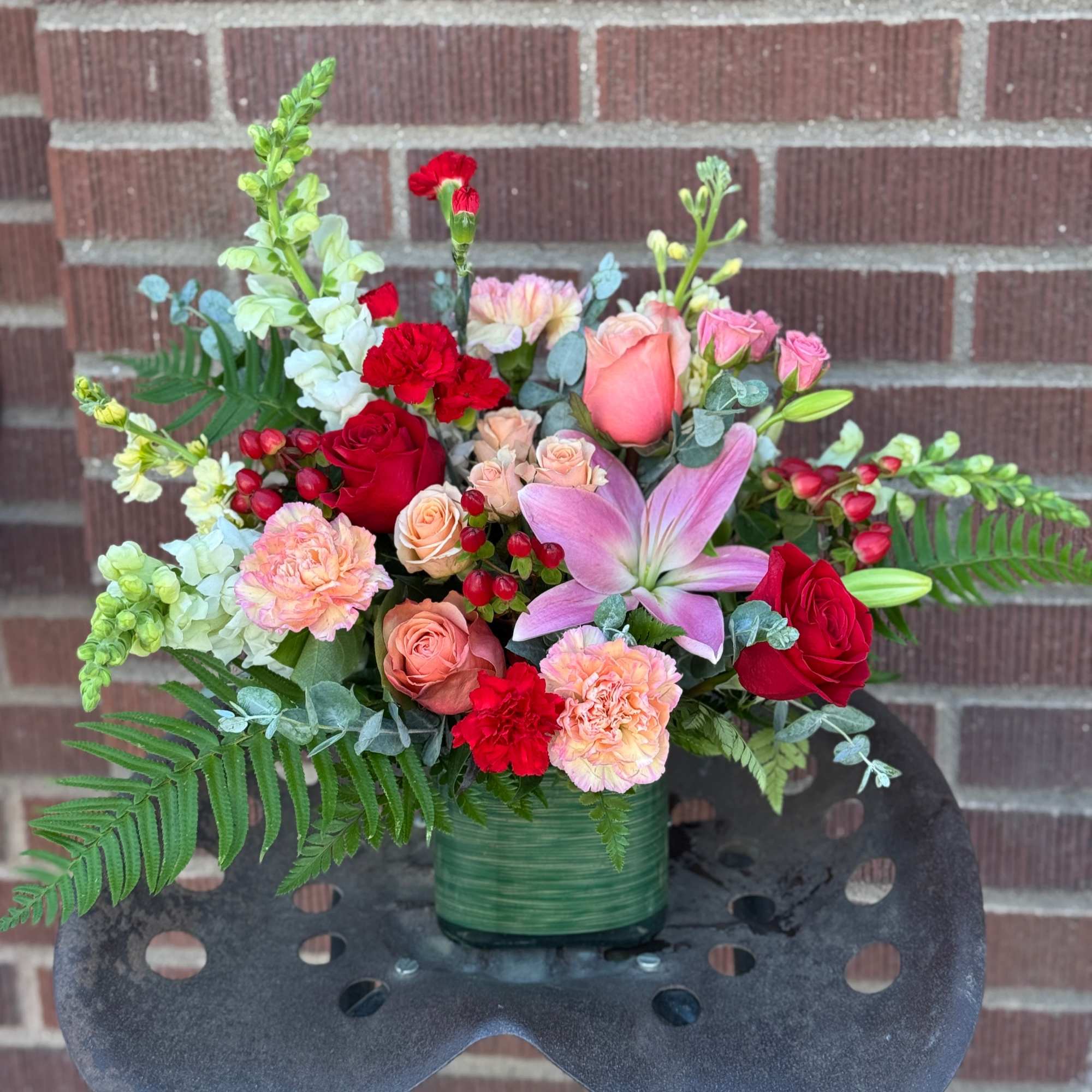 In deep red & peaches, featuring roses, carnations and snapdragons/larkspur. Arriving in In deep red & peaches, featuring roses, carnations and snapdragons/larkspur. Arriving in