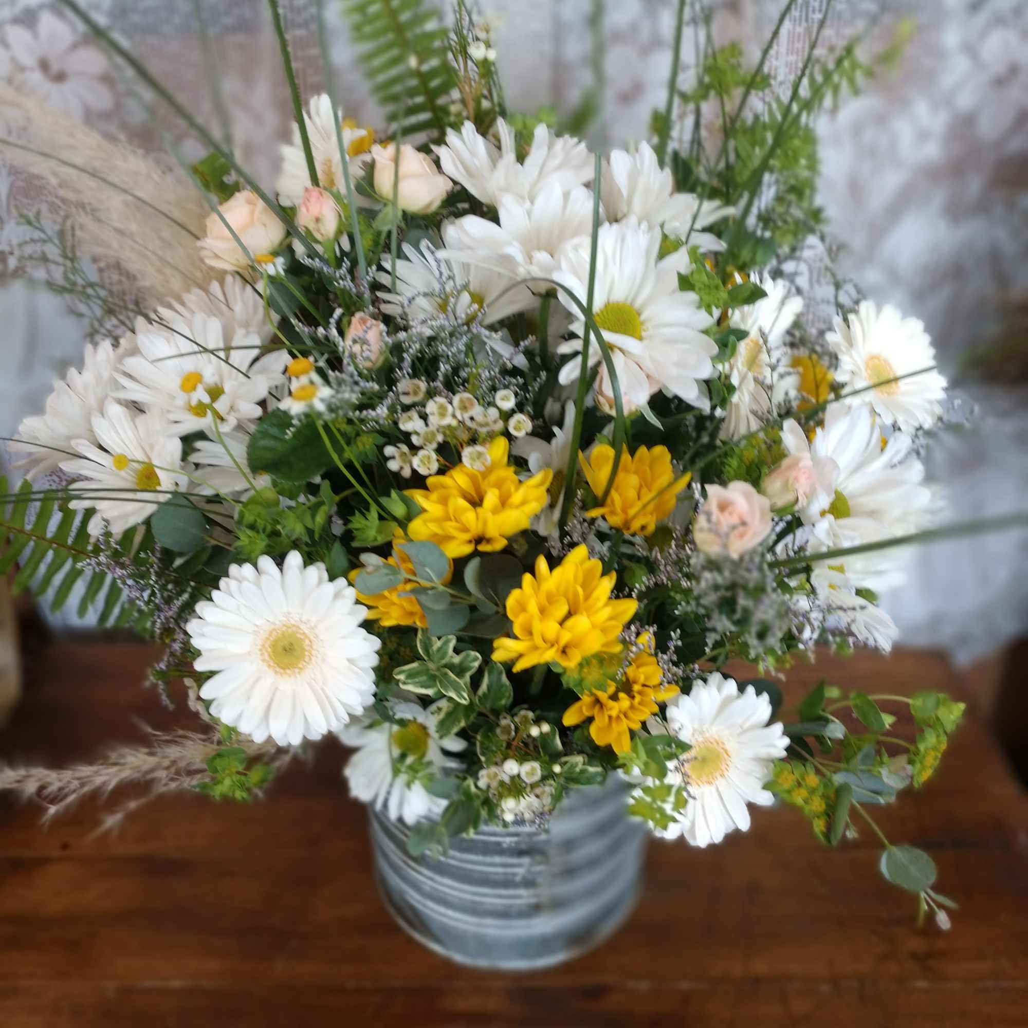 A galvanized tin container (different than pictured) with assorted white and yellow