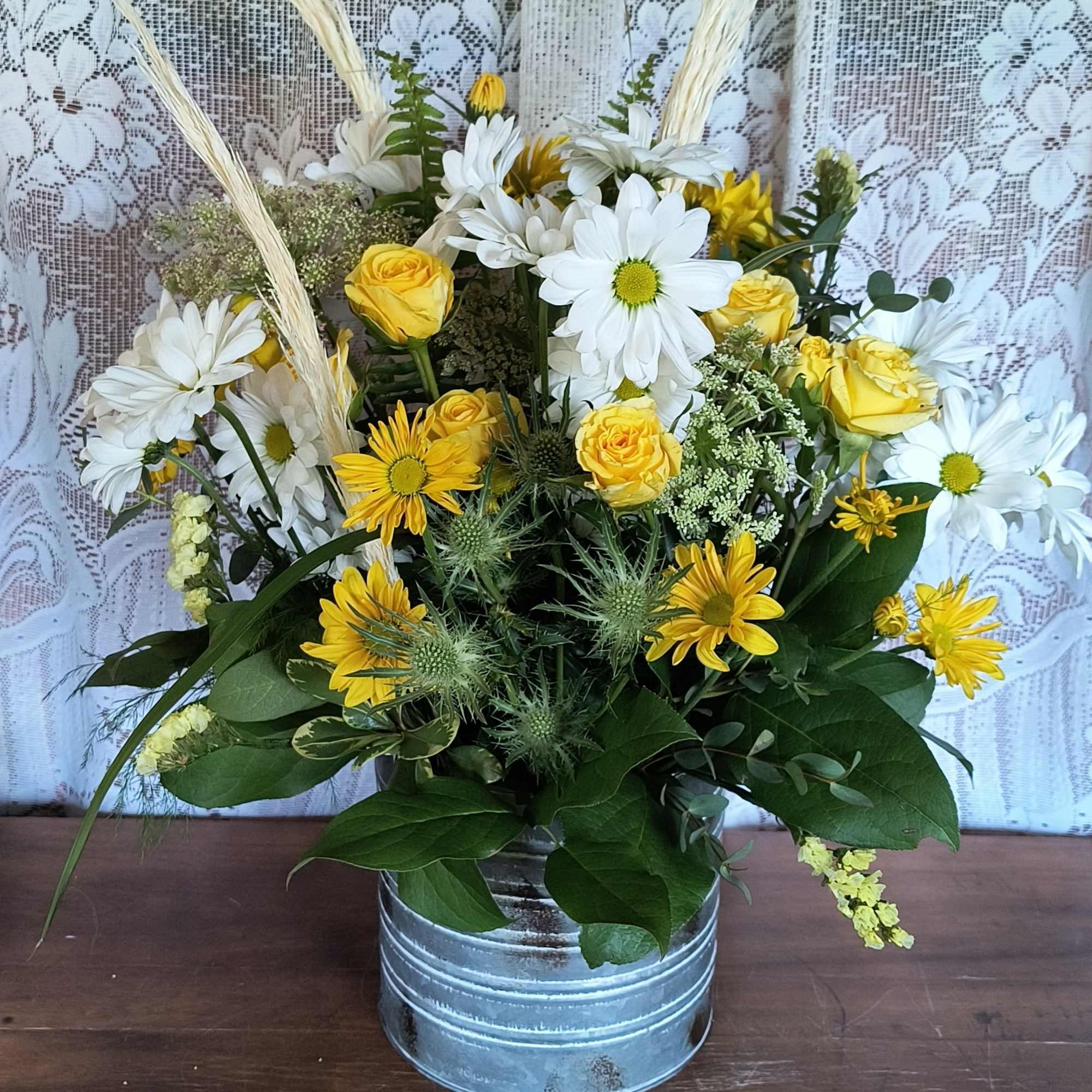 A galvanized tin container (different than pictured) with assorted white and yellow