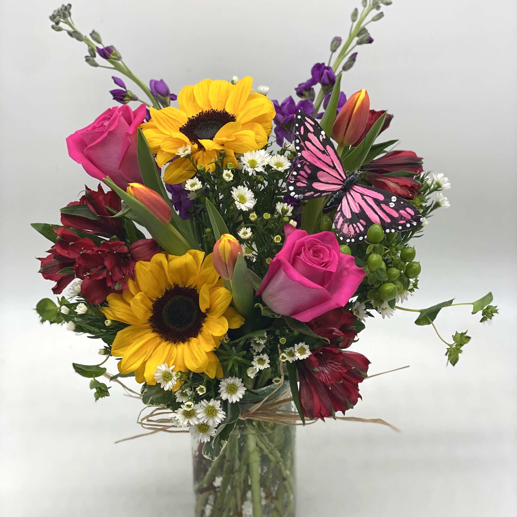 Bright mix of blooms designed in a hammered mason jar and finished