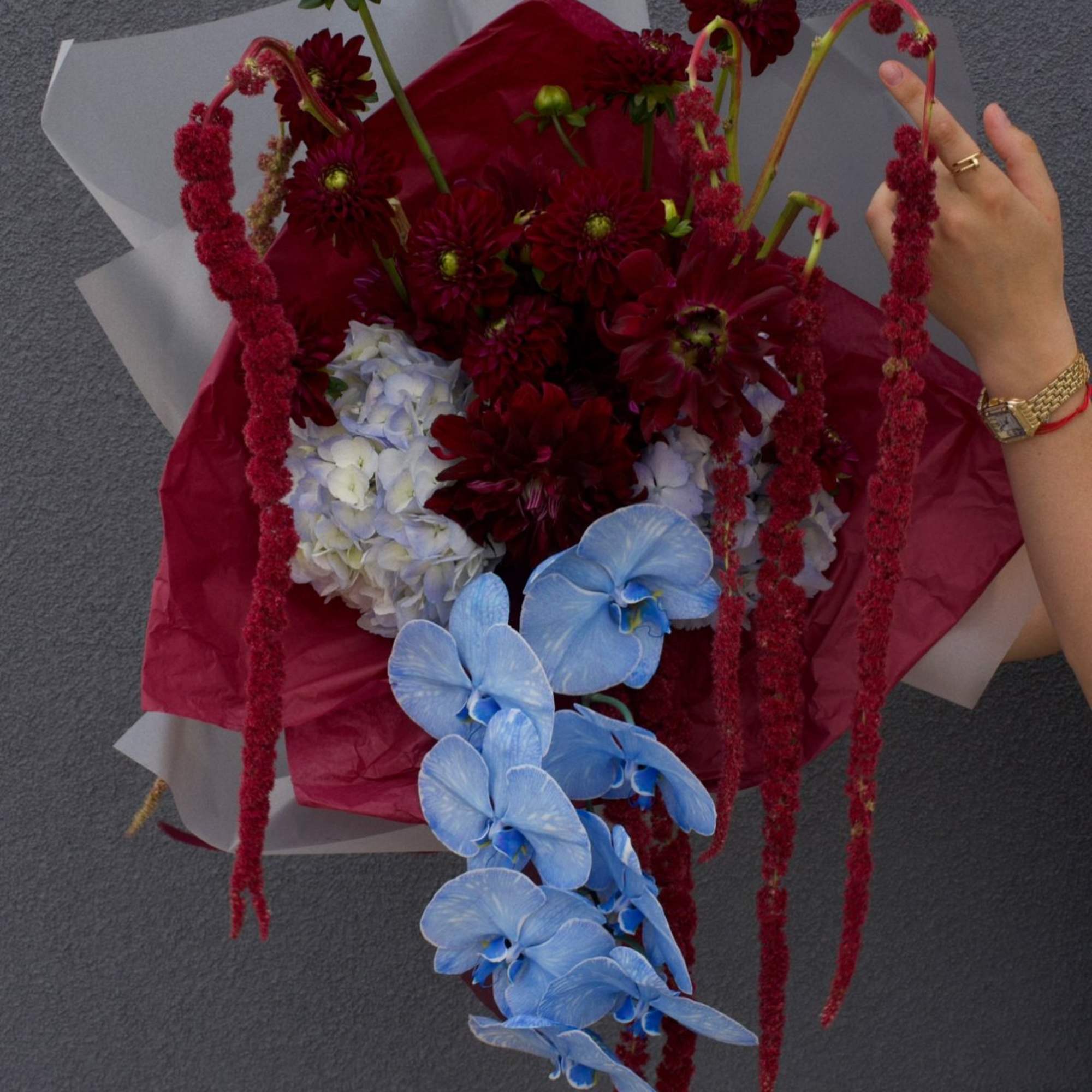 A striking fusion of deep burgundy dahlias and cascading amaranthus, electrified by