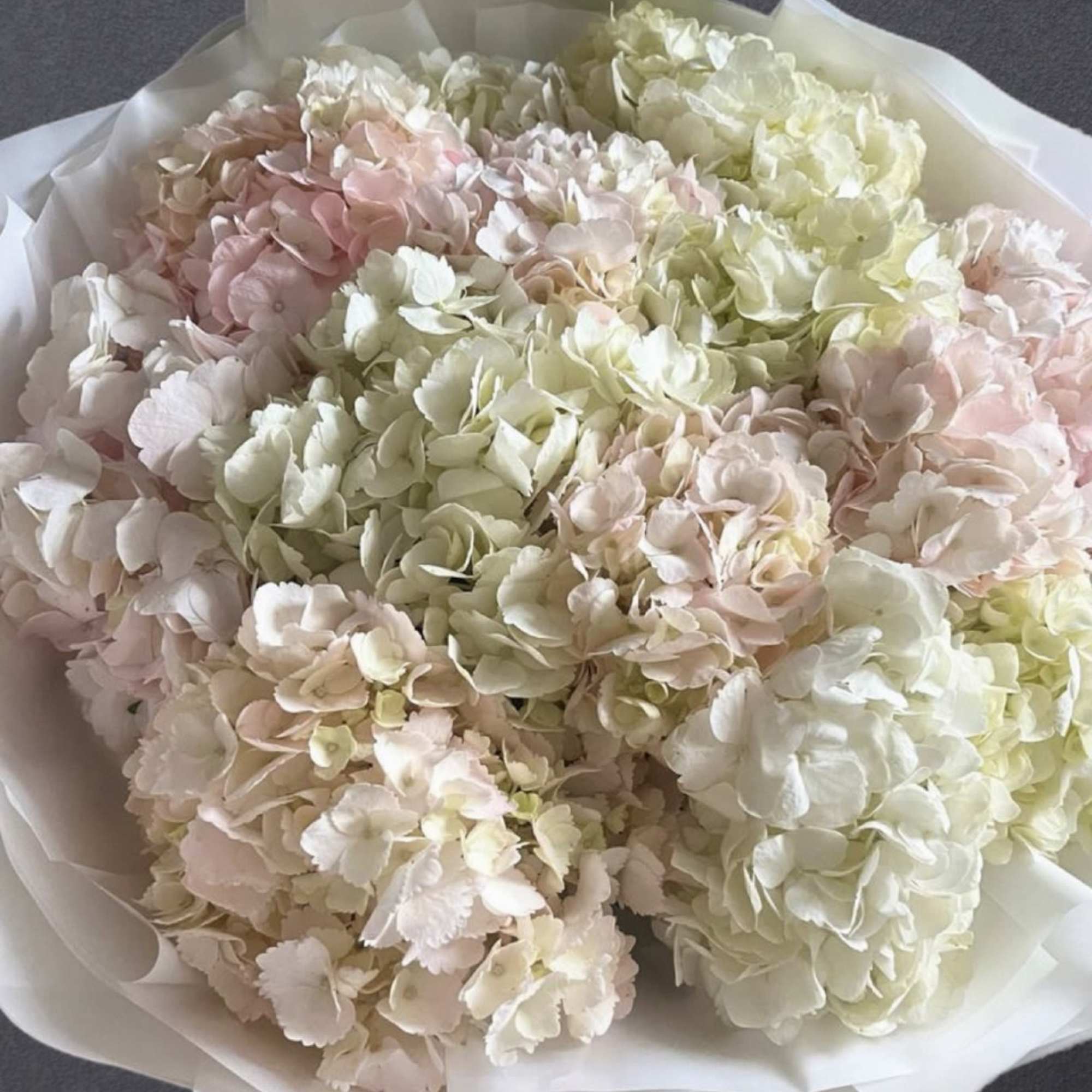 A voluminous bouquet in soft ivory, blush, and pastel hues &mdash; pure