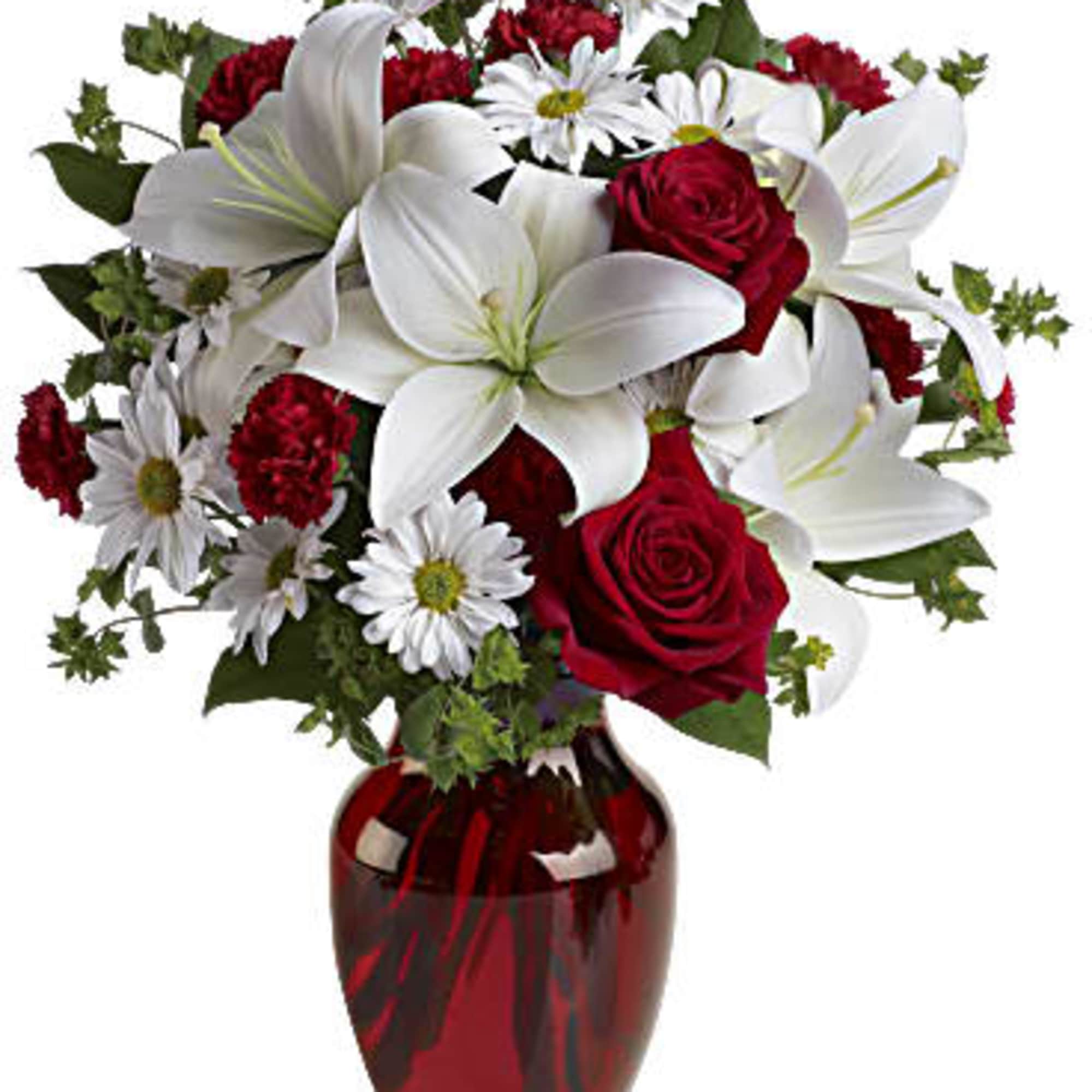 Bold red roses and pristine white lilies are artfully designed in a