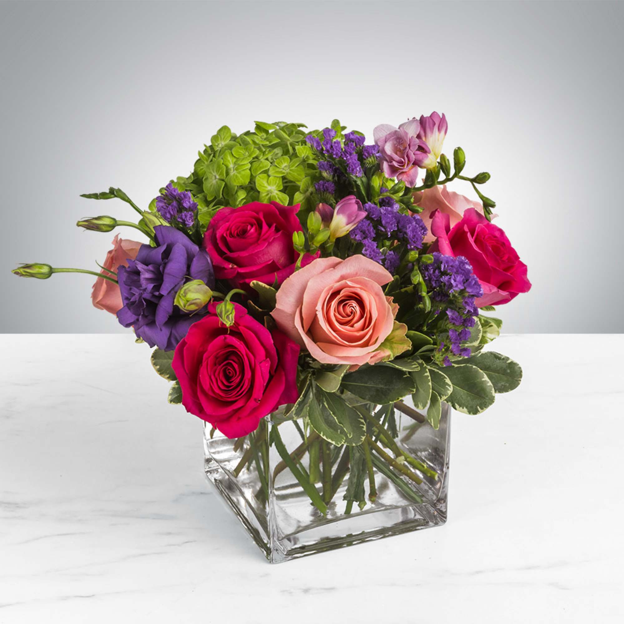 Beautiful centerpiece- This arrangement includes hot pink roses, pink roses, green hydrangea