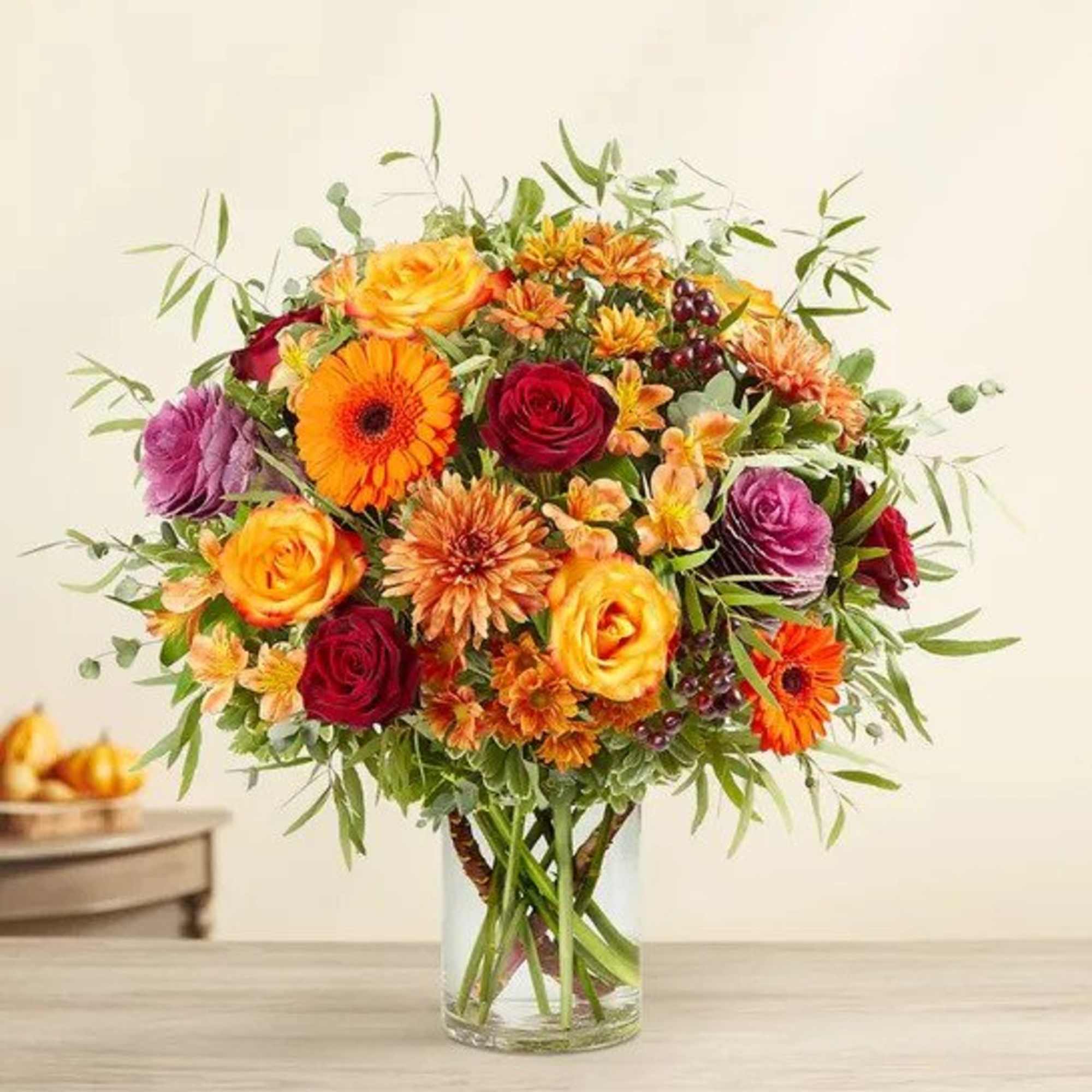 All-around arrangement with red roses, autumn-colored roses and daisy poms, orange Gerbera
