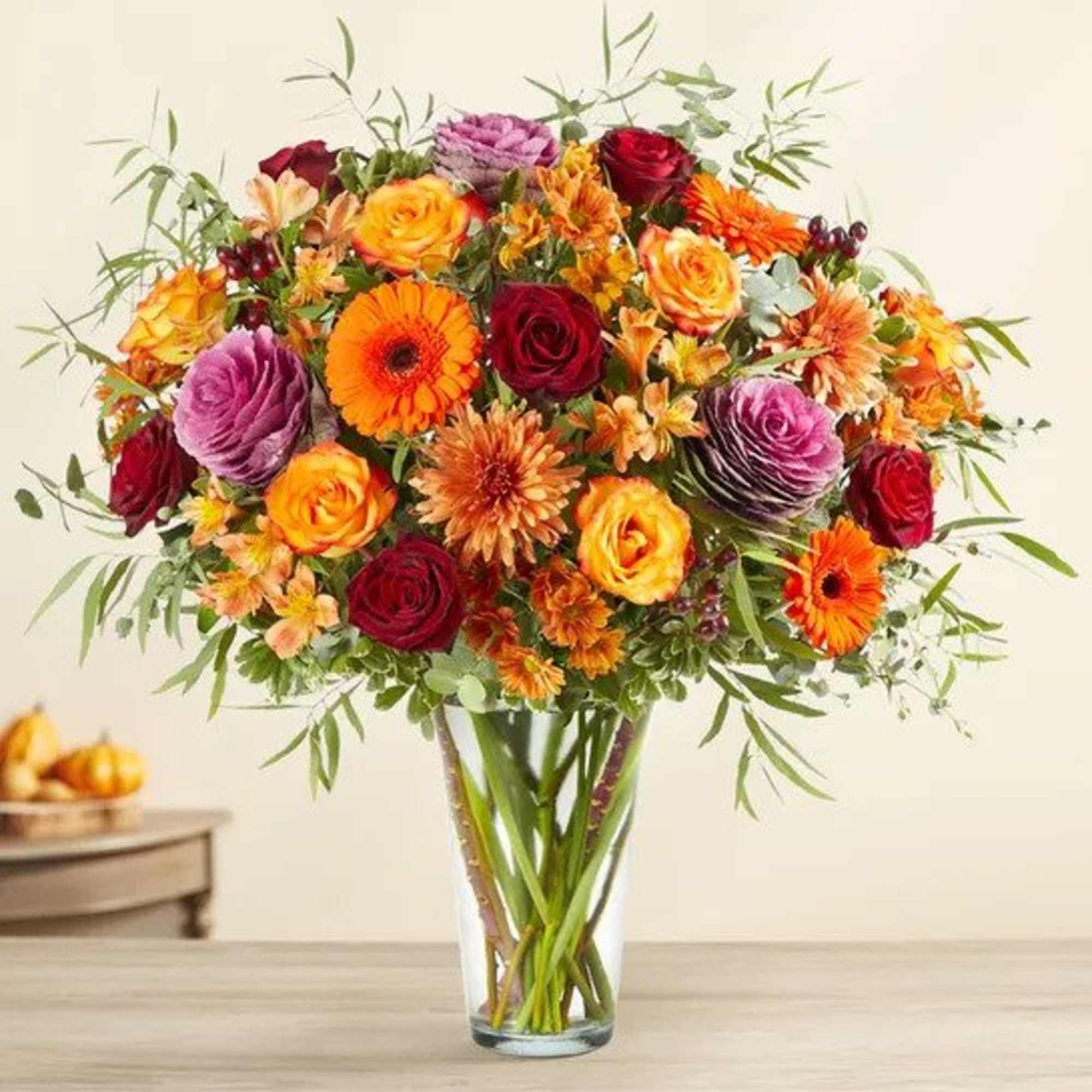 All-around arrangement with red roses, autumn-colored roses and daisy poms, orange Gerbera