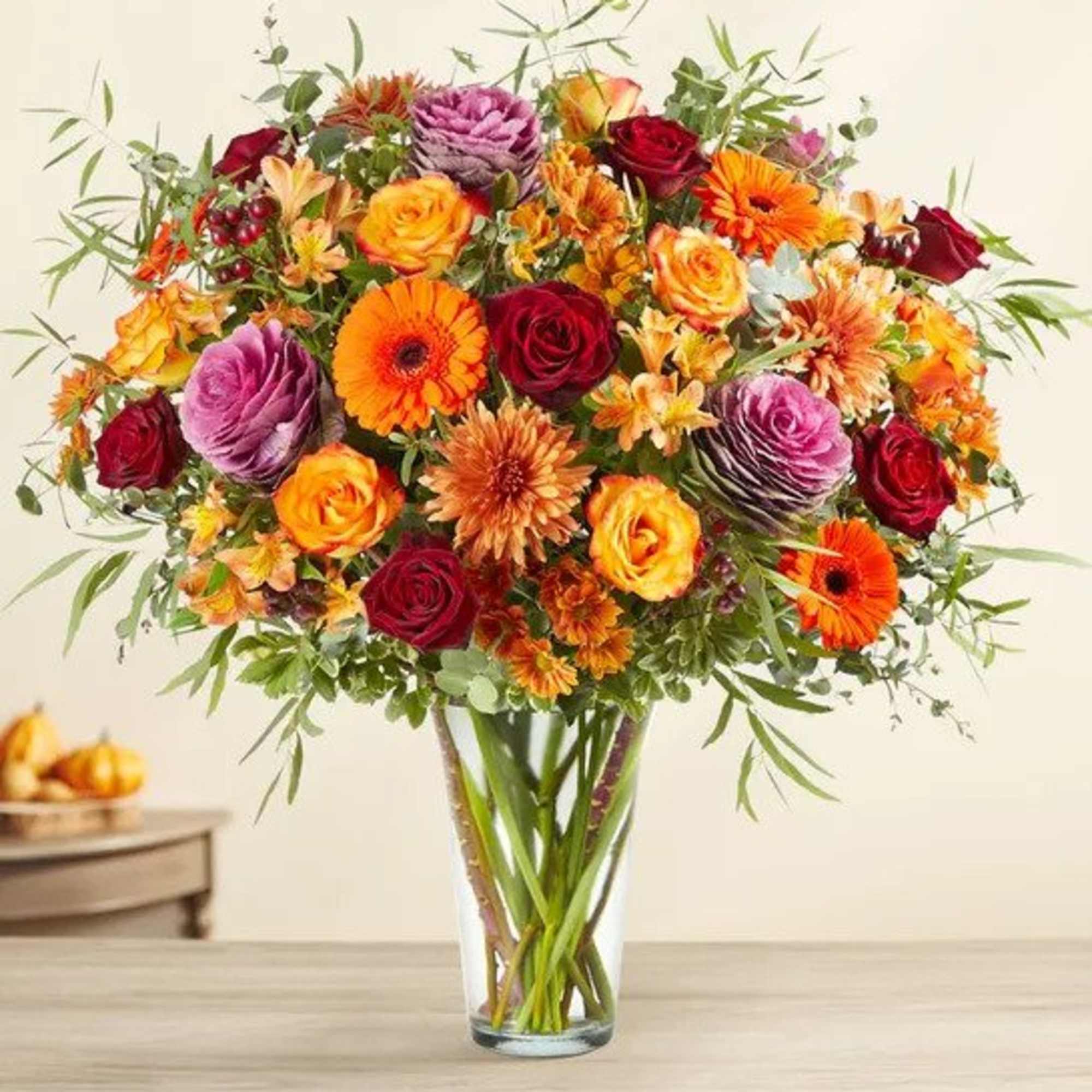 All-around arrangement with red roses, autumn-colored roses and daisy poms, orange Gerbera