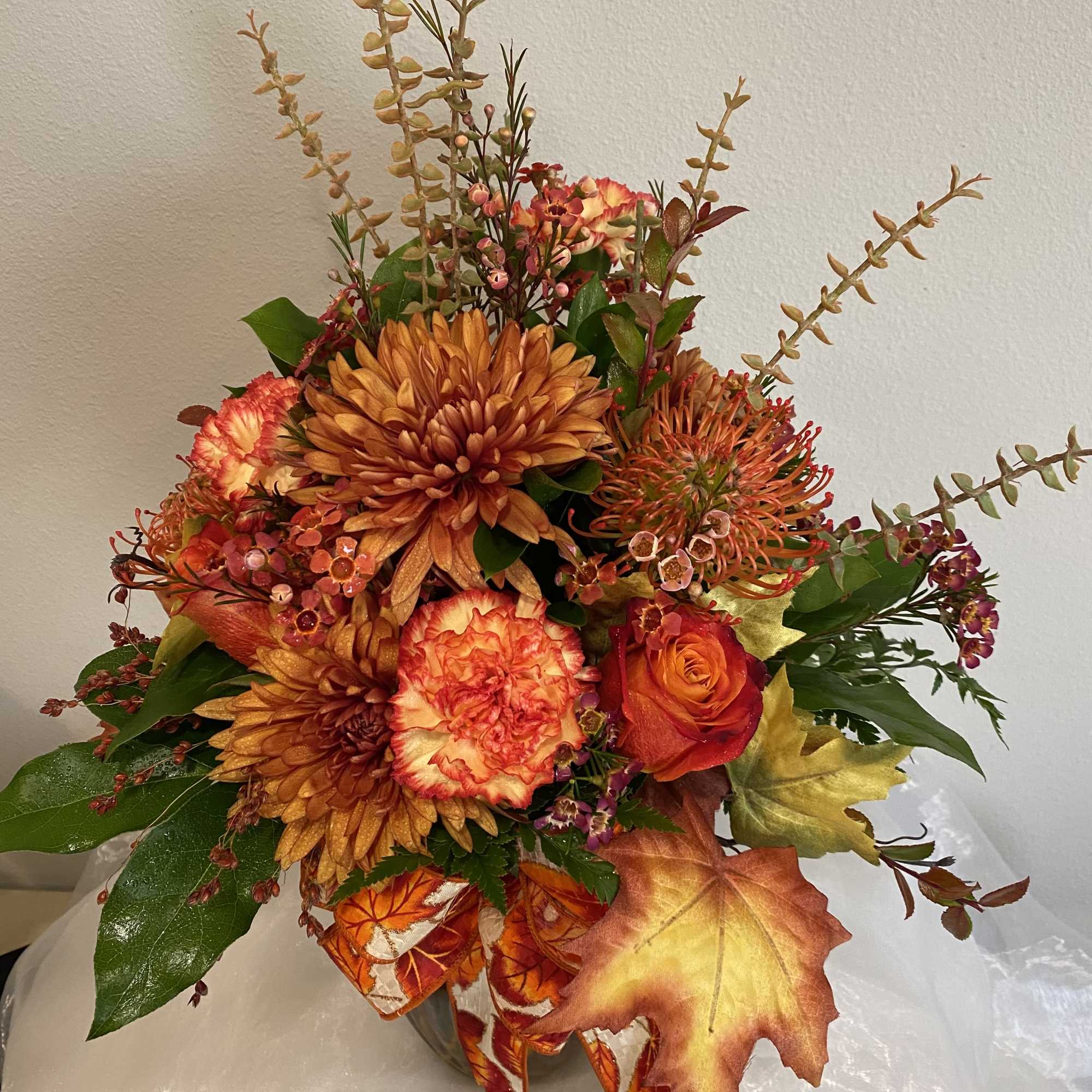 This vase arrangement has all the beautiful colors of fall.
Roses, carnations, protea