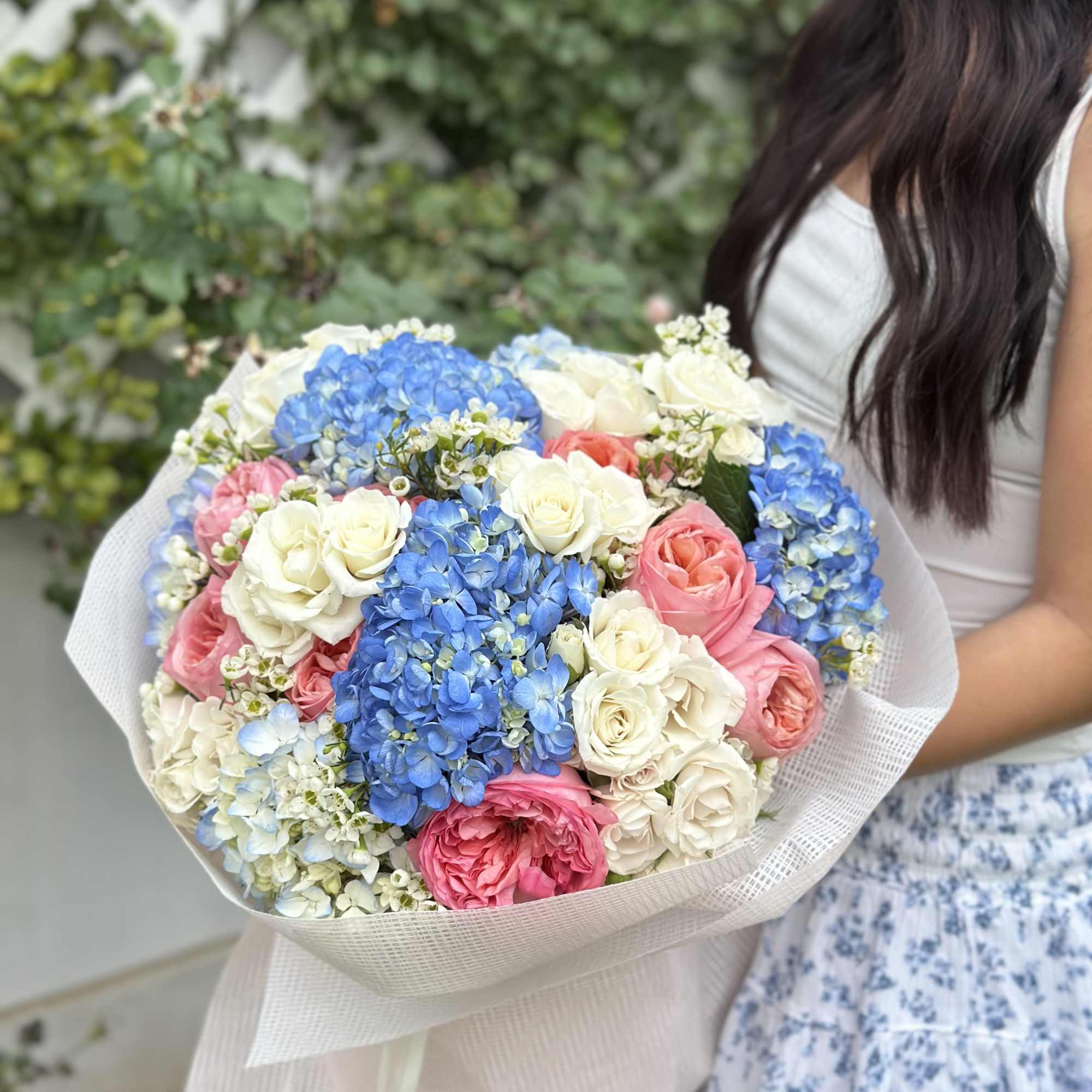 A vibrant and elegant bouquet featuring sky-blue hydrangeas, creamy white roses