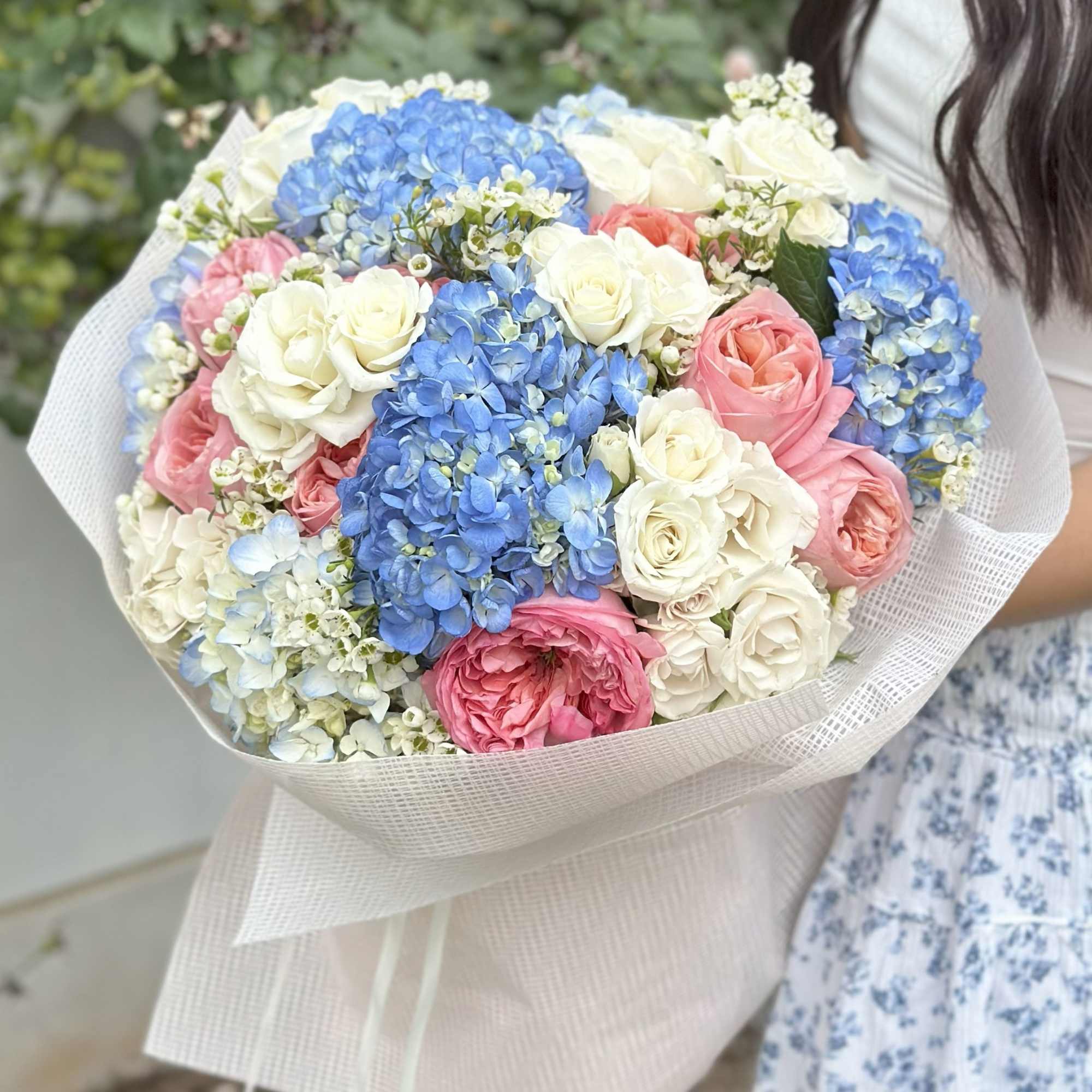  A vibrant and elegant bouquet featuring sky-blue hydrangeas, creamy white roses
