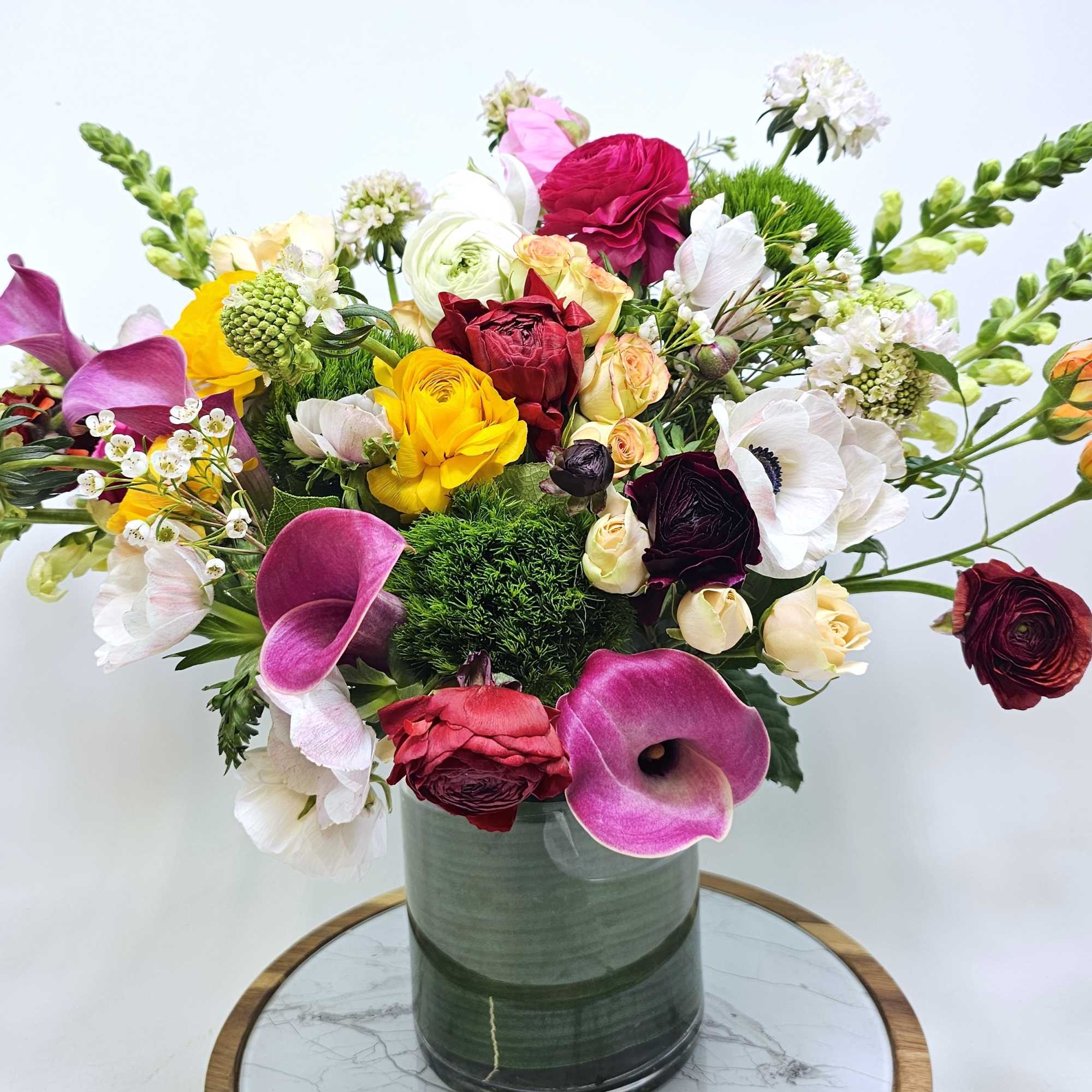 Bright, heartwarming arrangement made to make anyone&#039;s day brighter. Filled with ranunculus