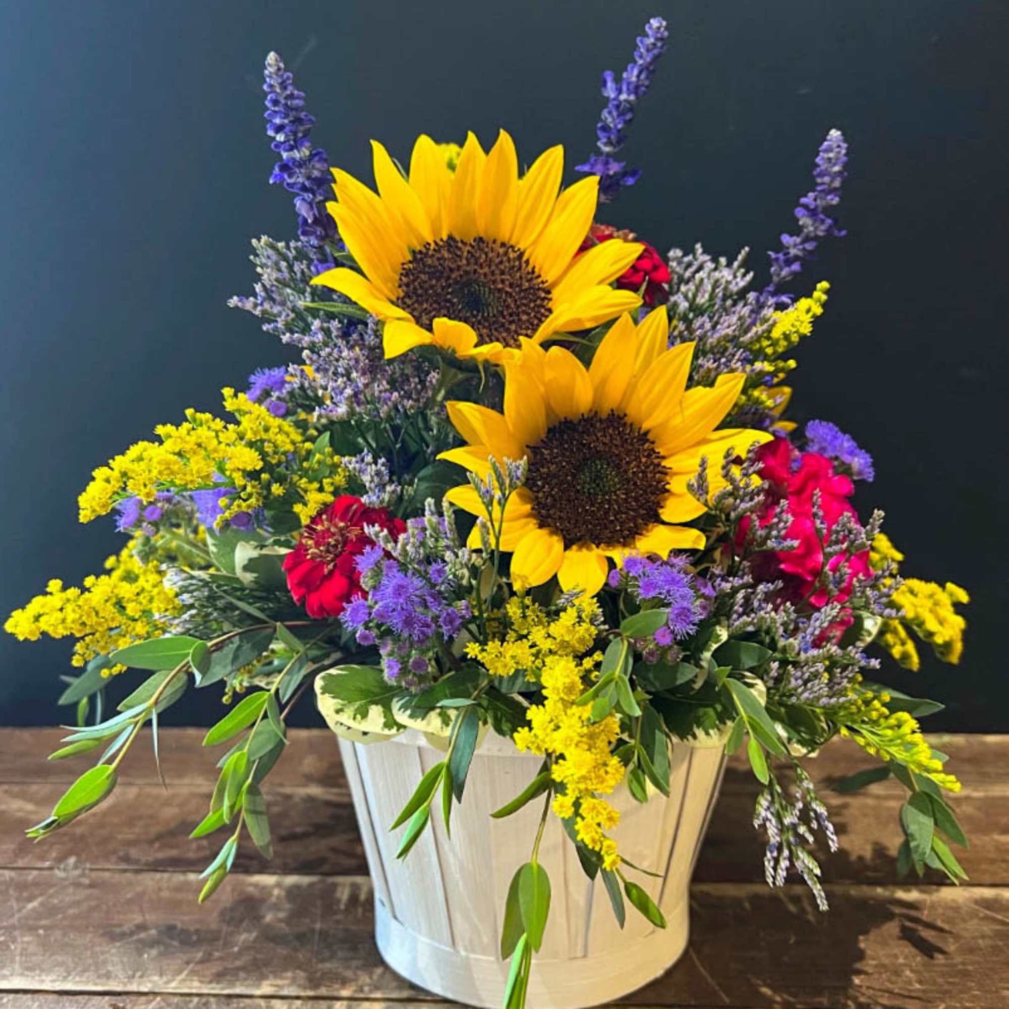 A delightful basket of farm fresh flowers. Including sunflowers, solidago, zinnias and