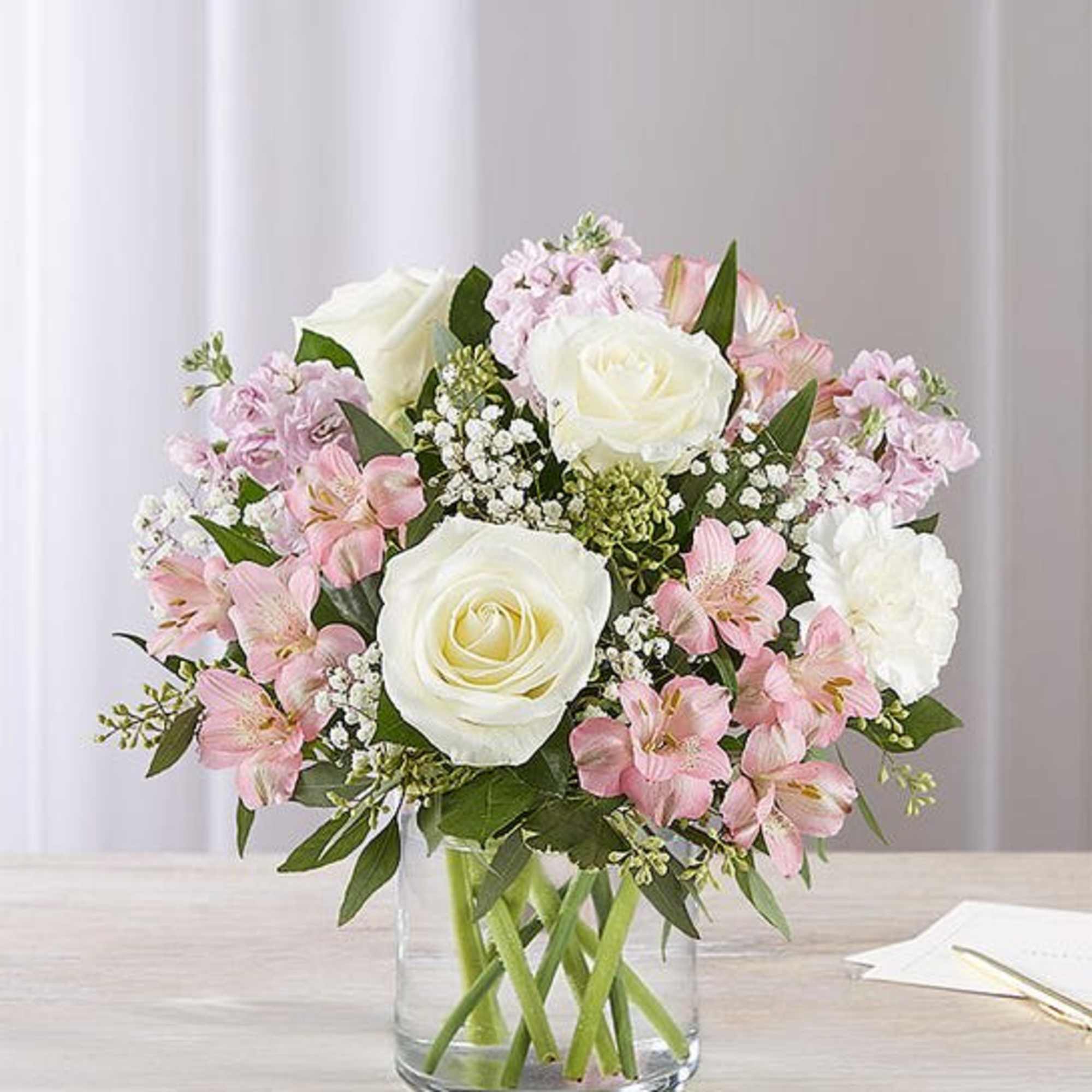 Our graceful arrangement in shades of blush pink and creamy white is