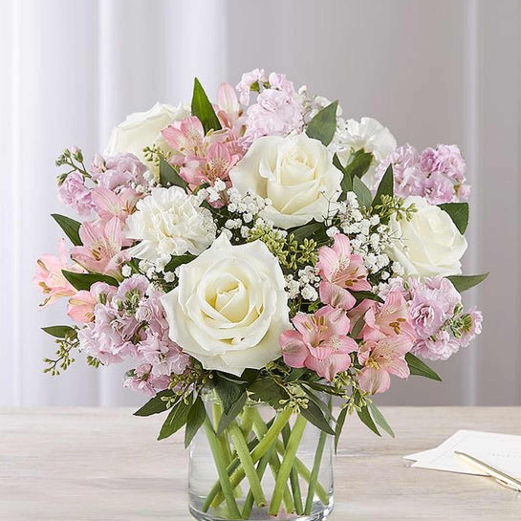 Our graceful arrangement in shades of blush pink and creamy white is