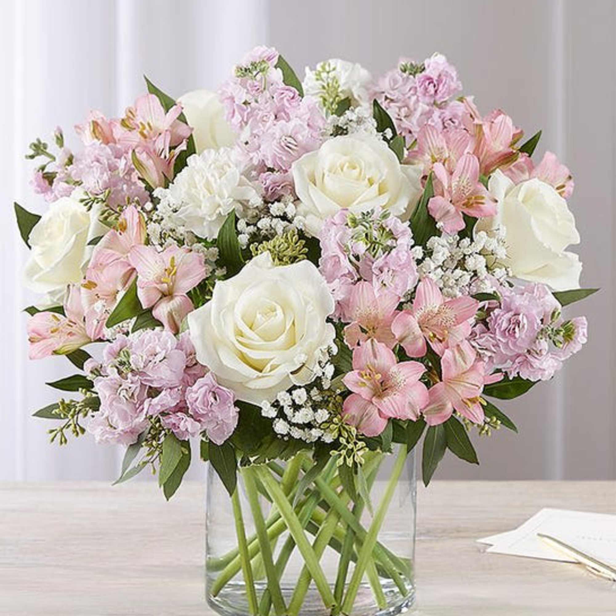 Our graceful arrangement in shades of blush pink and creamy white is