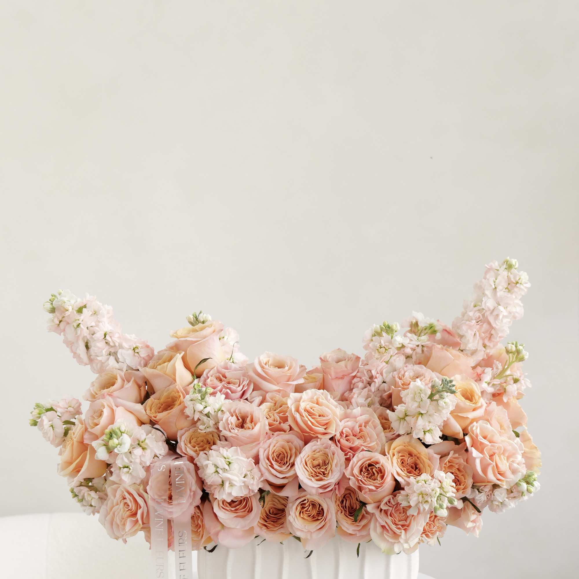 Warm and graceful, Divine Sunset features soft peach roses and delicate blooms Warm and graceful, Divine Sunset features soft peach roses and delicate blooms