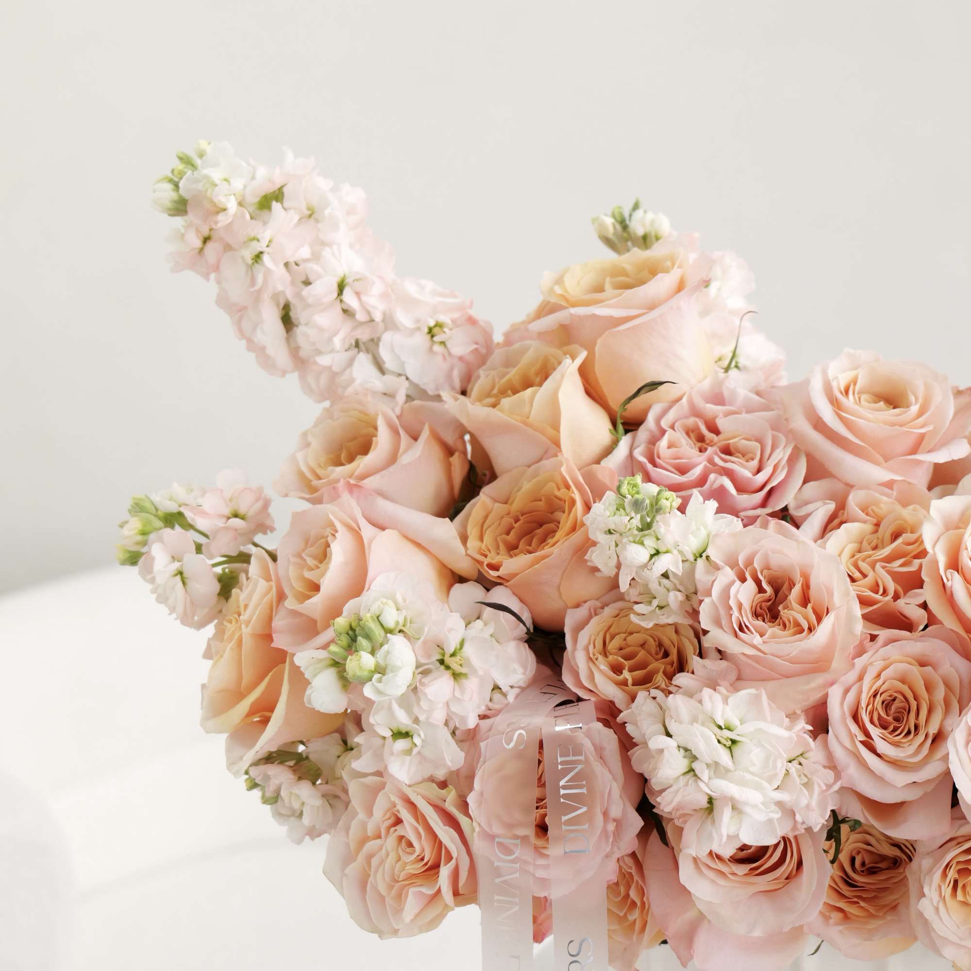 Warm and graceful, Divine Sunset features soft peach roses and delicate blooms Warm and graceful, Divine Sunset features soft peach roses and delicate blooms