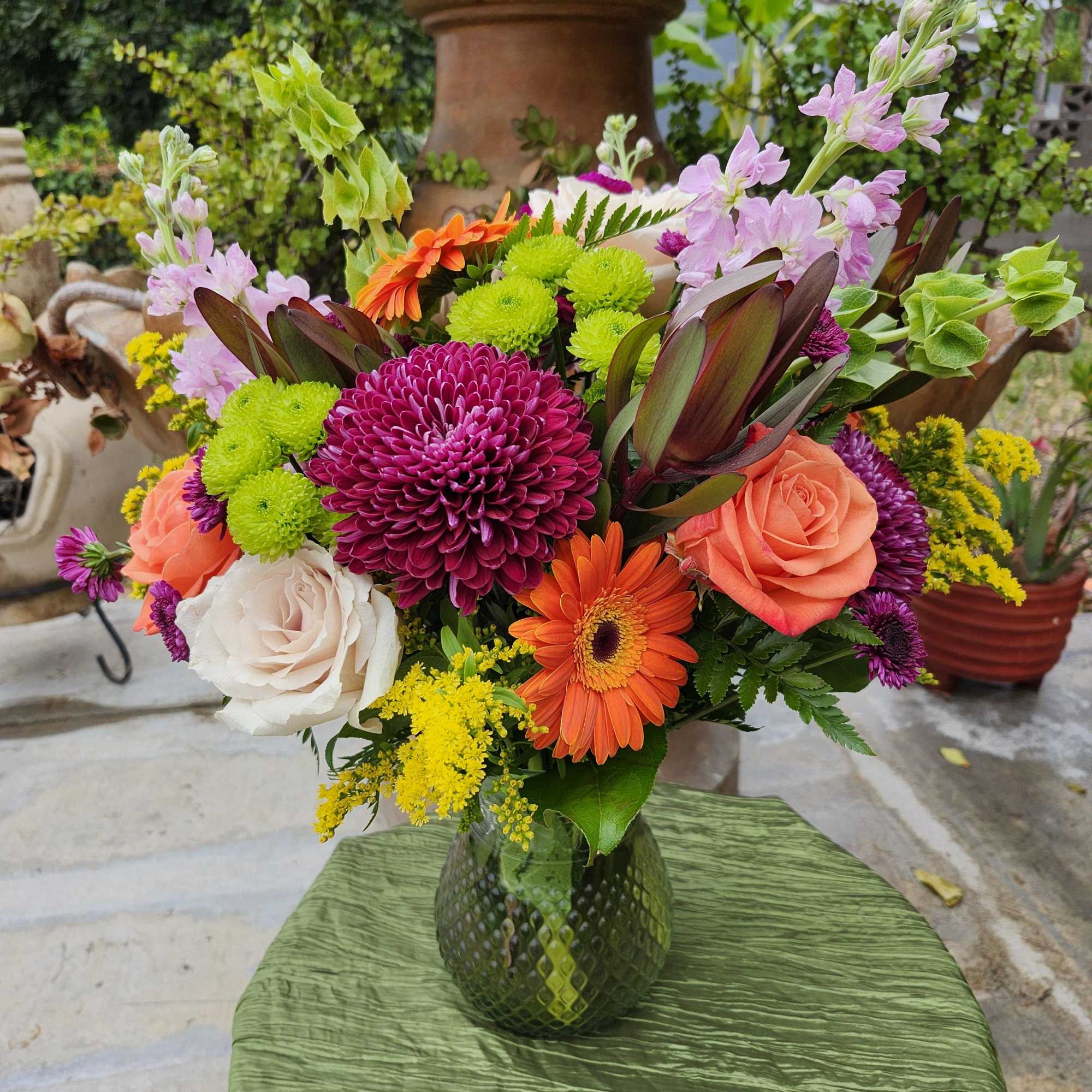 Fall colors of various flowers for this full all around vase bouquet.
