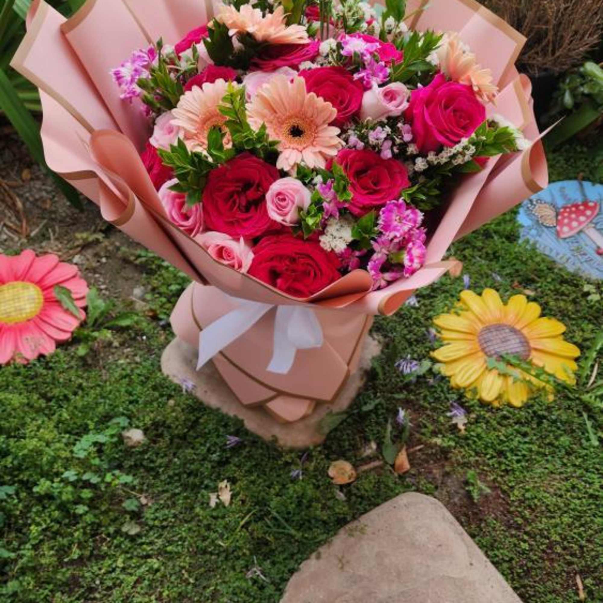 This wrap bouquet shown in large.
2 dozen roses designer's choice. All florals