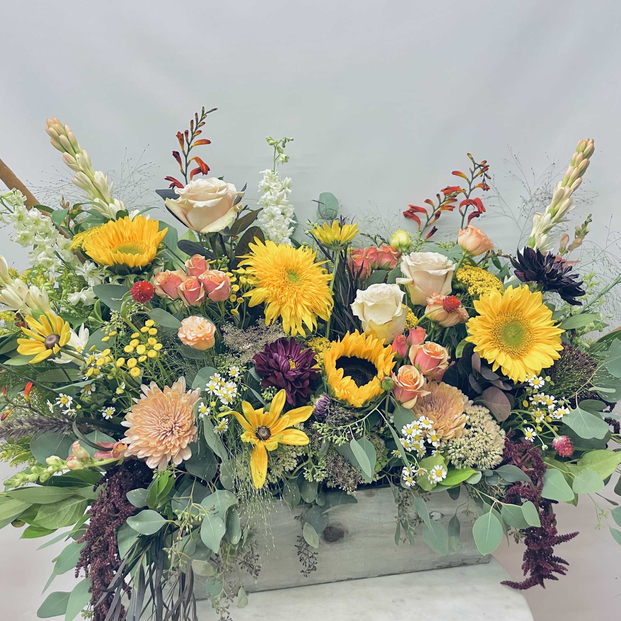 Moody autumnal palette of mixed blooms including sunflowers, roses, snapdragons, ranunculus, seasonal