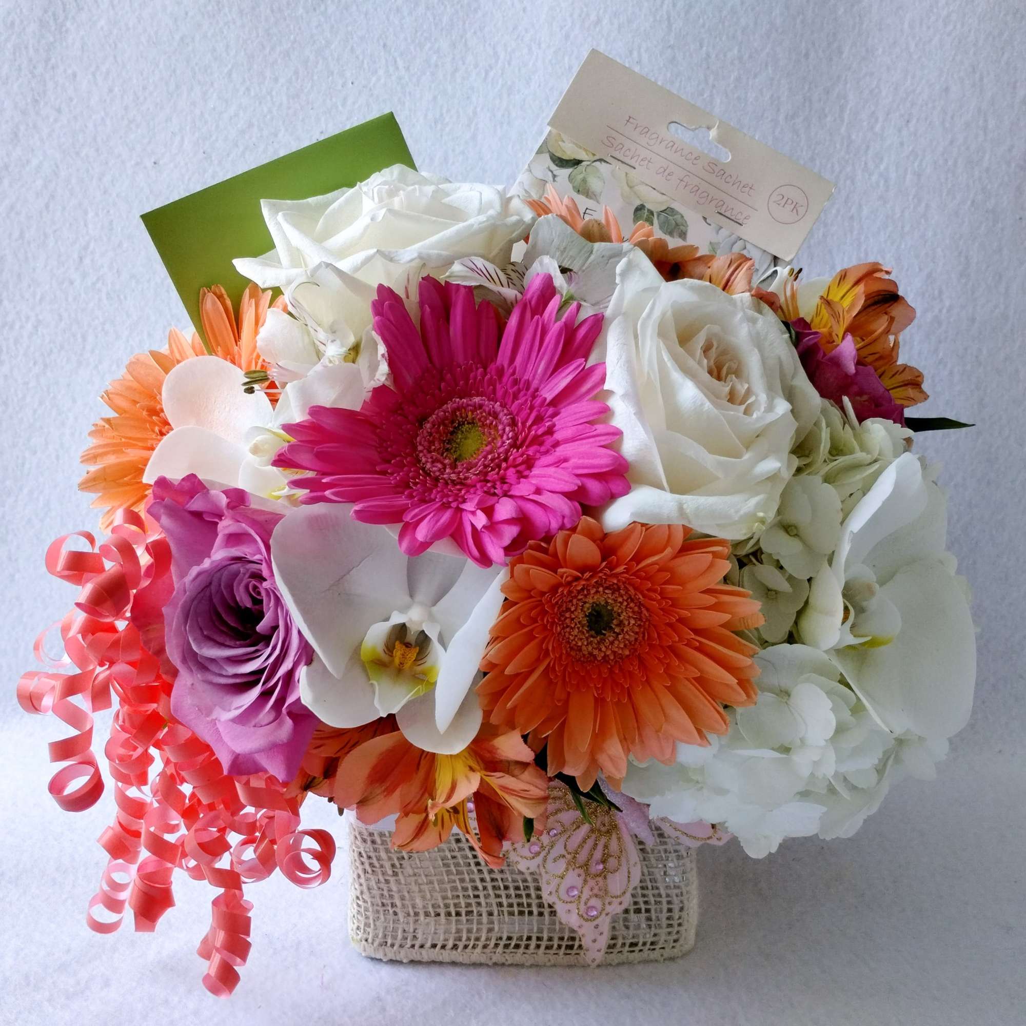 Lovely roses orchids and so much more arranged in a modern glass