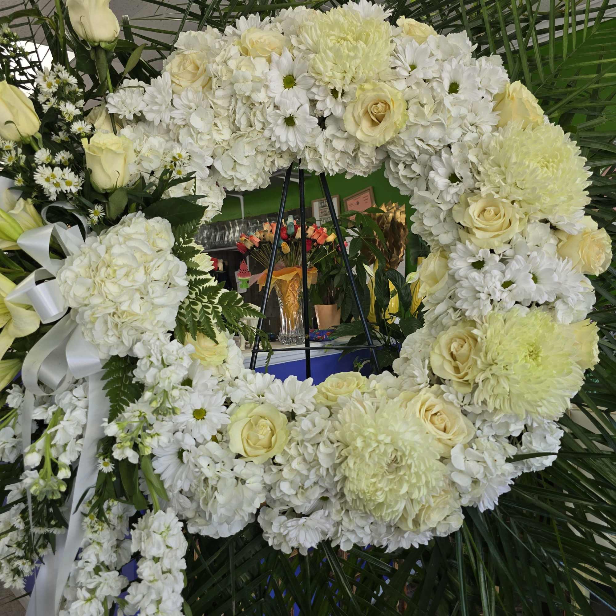 Wreath made of various white flowers with side focal piece.
