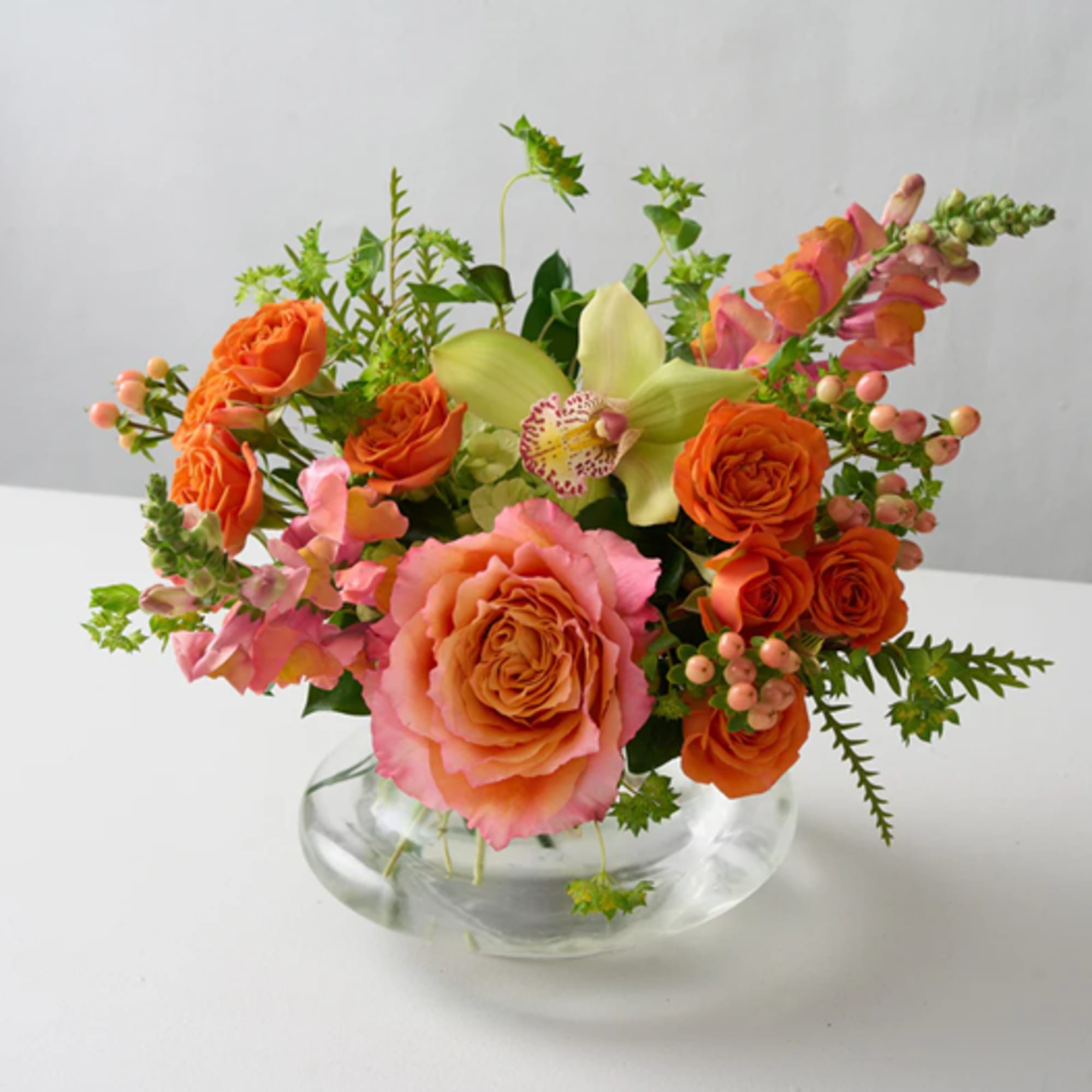 A lively pop of orange crush roses and cymbidium orchid greens, this A lively pop of orange crush roses and cymbidium orchid greens, this