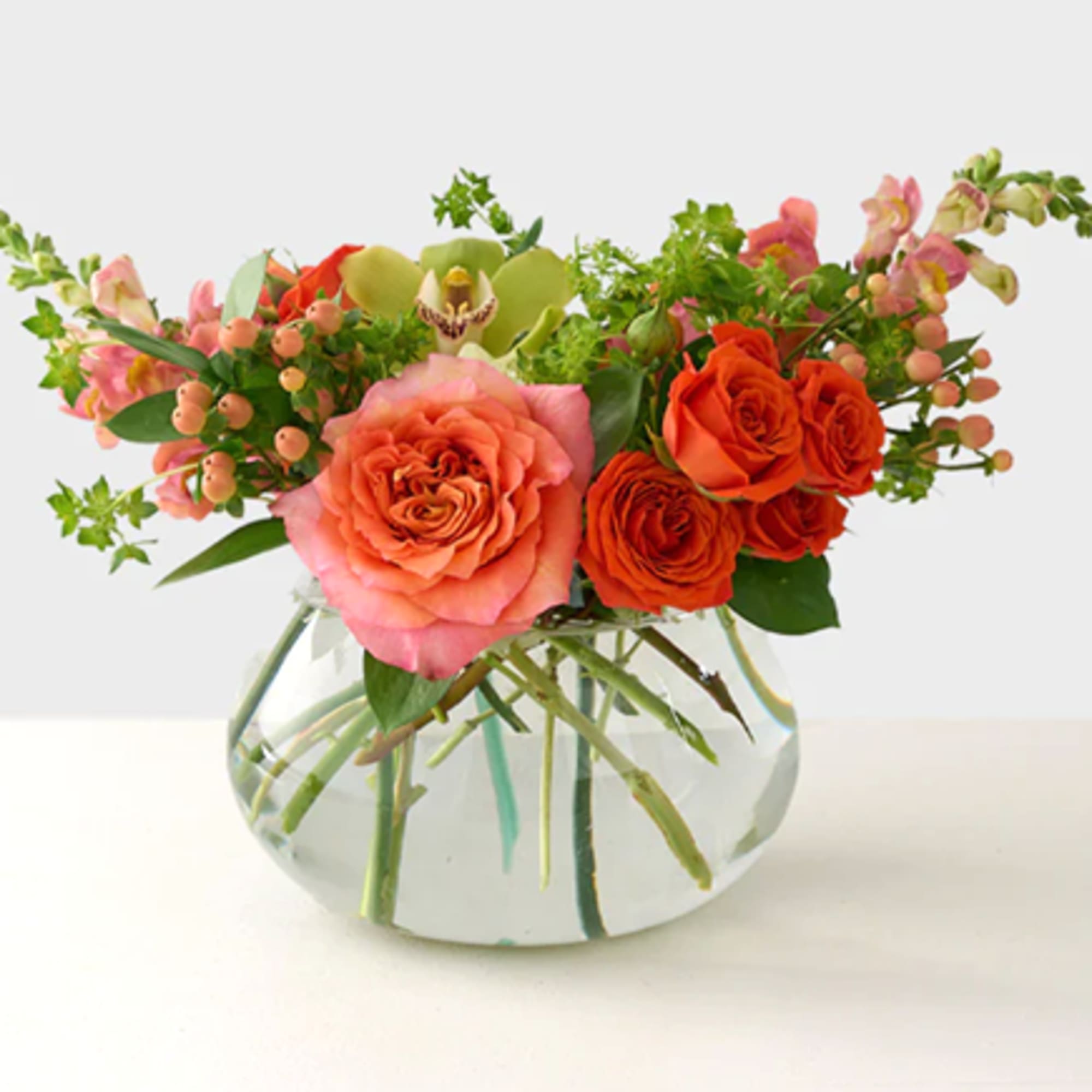 A lively pop of orange crush roses and cymbidium orchid greens, this A lively pop of orange crush roses and cymbidium orchid greens, this